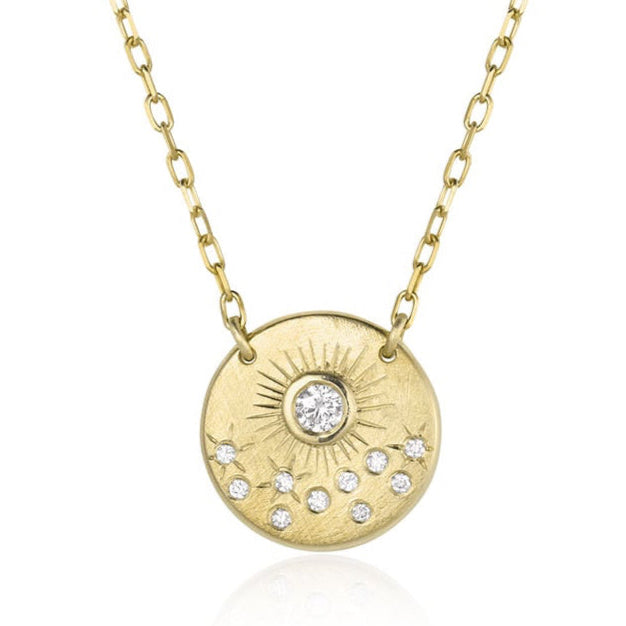 Gold necklace with a round pendant featuring diamonds on a paperclip link chain against a white background