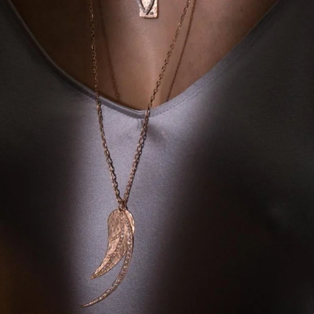 14k gold leaf pendant with pave set white diamonds in lifestyle shot