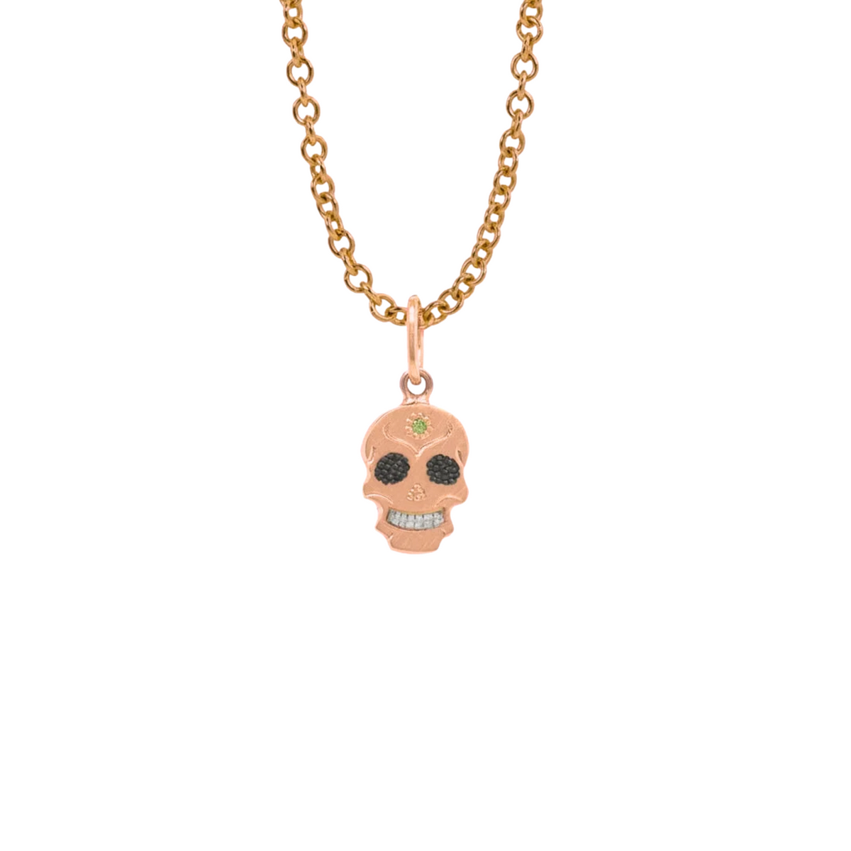 A Teeny Tiny collection rose gold charm in the shape of a sugar skull with a round apple green diamond in the center, displayed on a gold chain against a white background.
