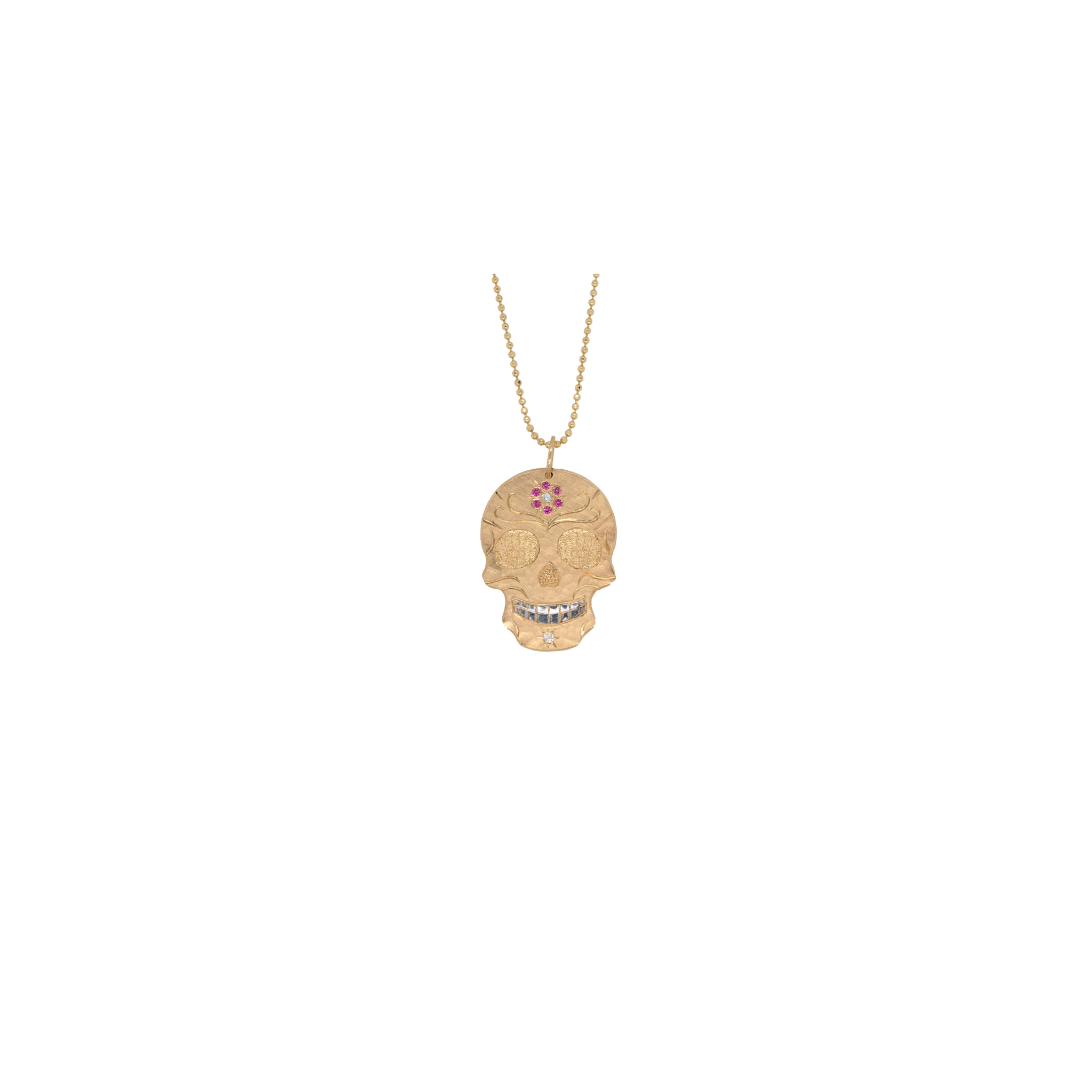Gold skull necklace with gemstones on a white background by Julez Bryant