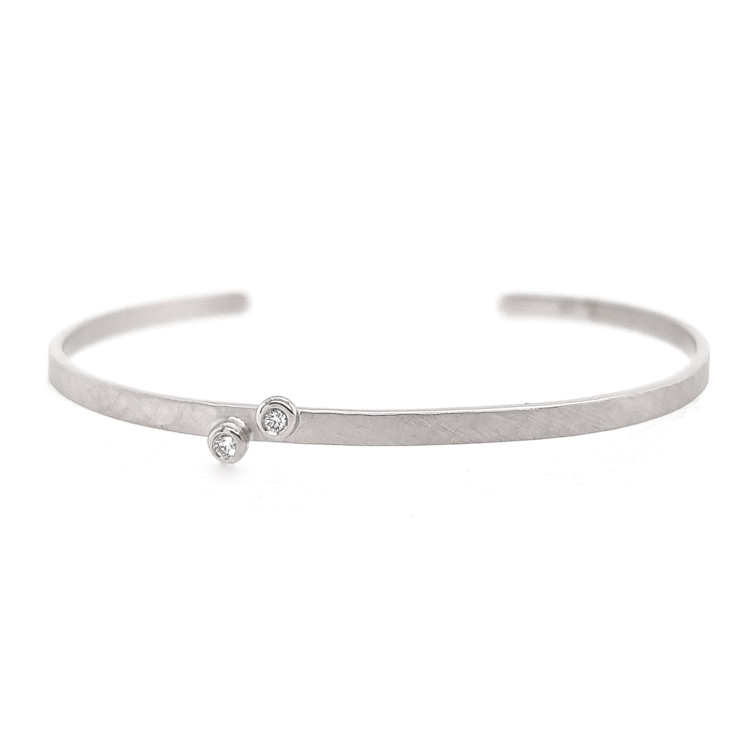 14k white gold hammered open cuff bracelet with two bezel set white diamonds on white background