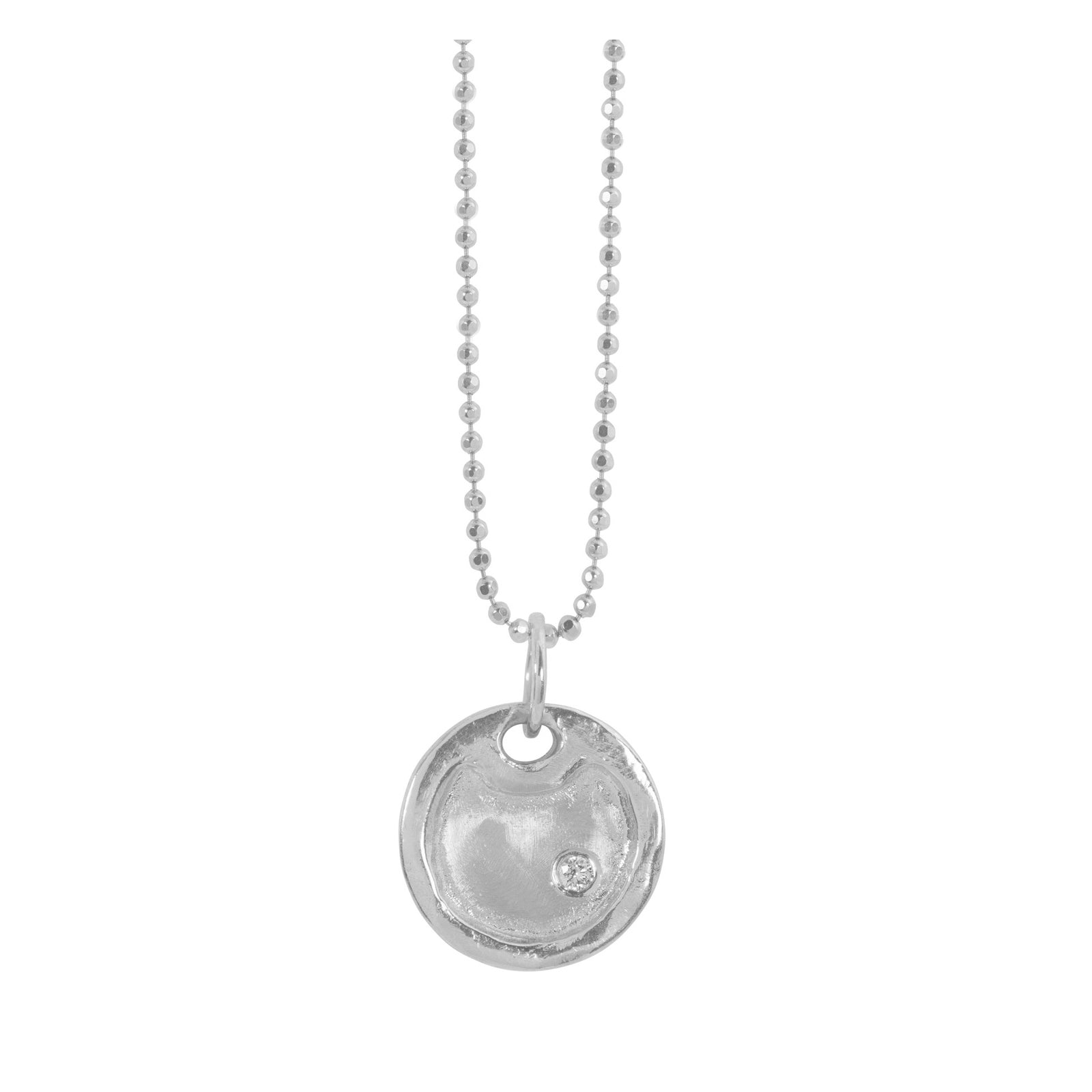 Small 14k white gold round dog tag pendant with raised polished border and single stone diamond accent hanging from diamond cut ball chain shown on white background