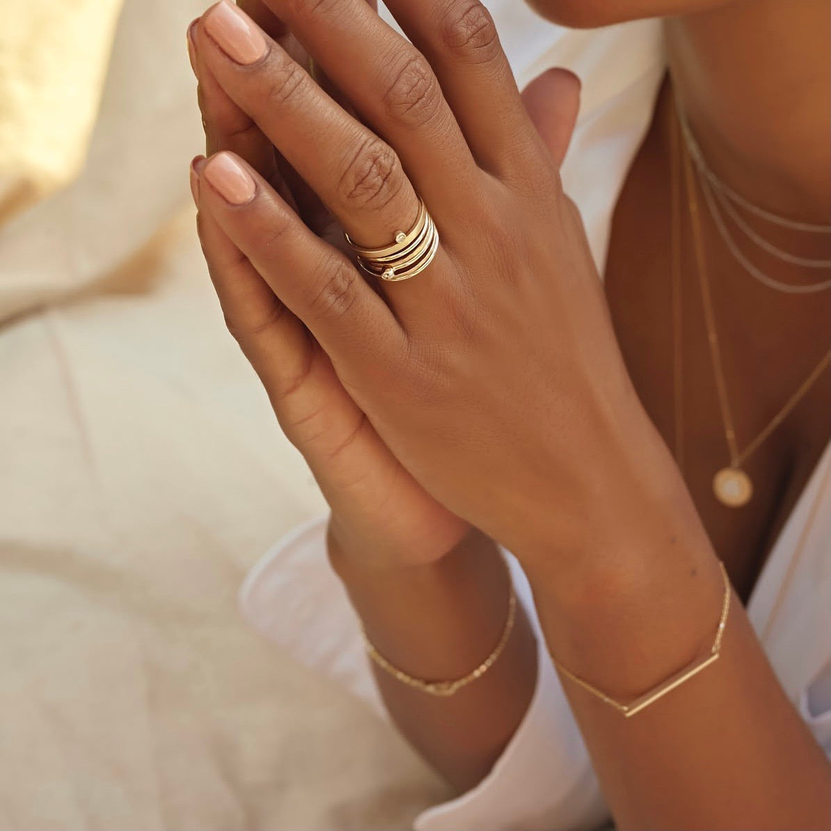 14k yellow gold ring with a bezel set white diamond stacked with julez bryant stackable rings on model in lifestyle shot