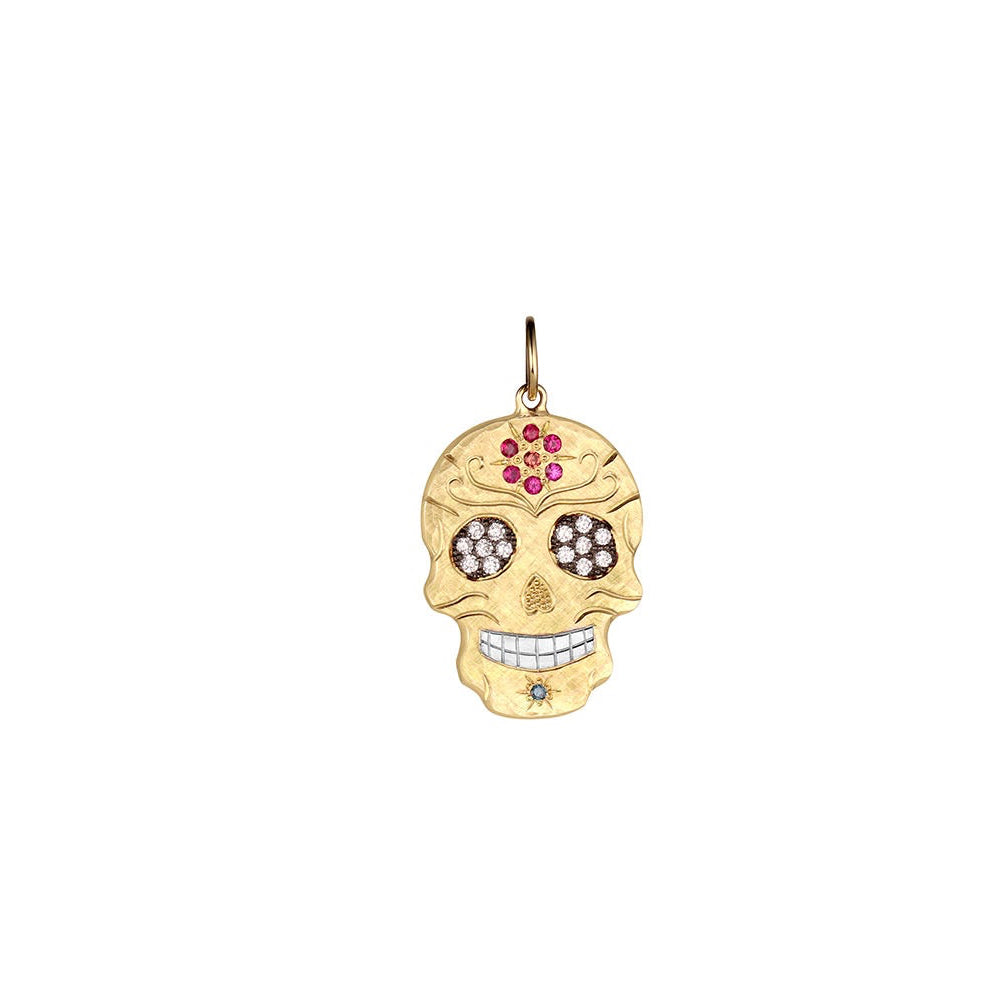Gold skull pendant with gemstones on a white background
