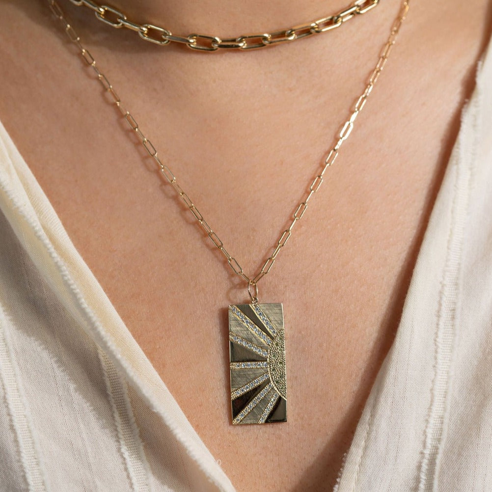 14k yellow gold rectangular sunray pendant with white and yellow diamond accents on a link chain paired with the mica choker on a model in lifestyle shot