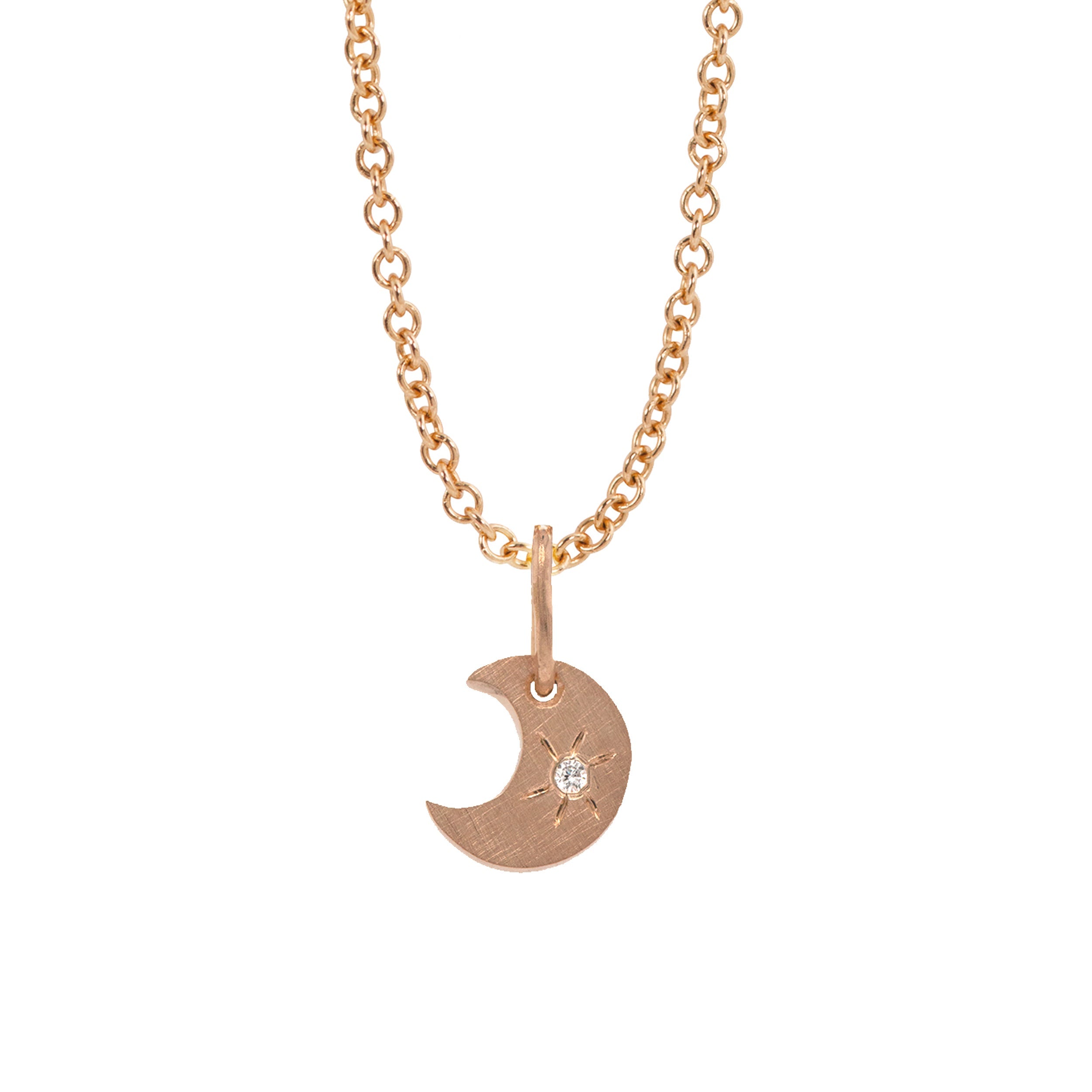 14k rose gold crescent moon charm with a white diamond sunburst on a rolo chain on a white background