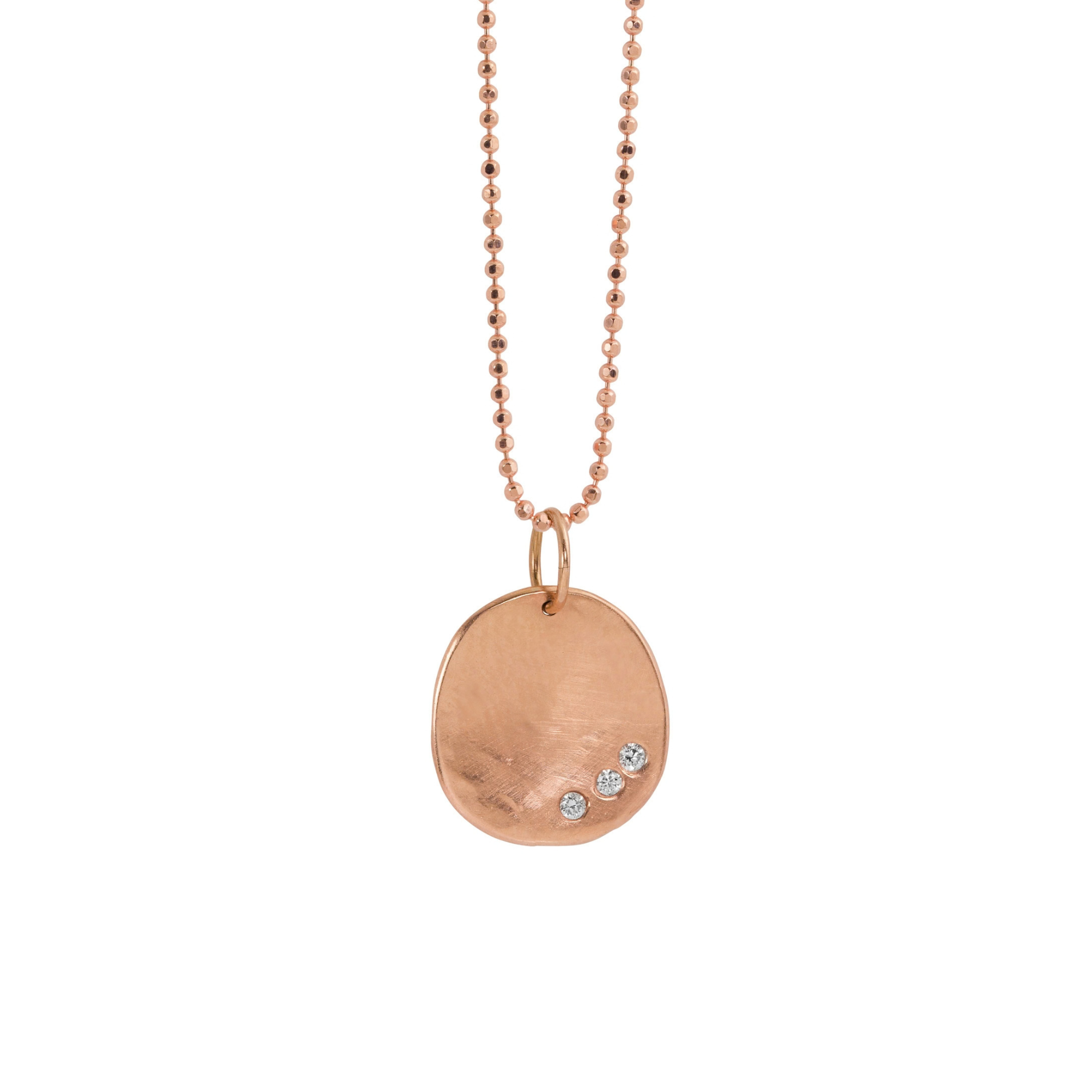 14k rose gold round hammered pendant featuring three small white diamonds on a white background