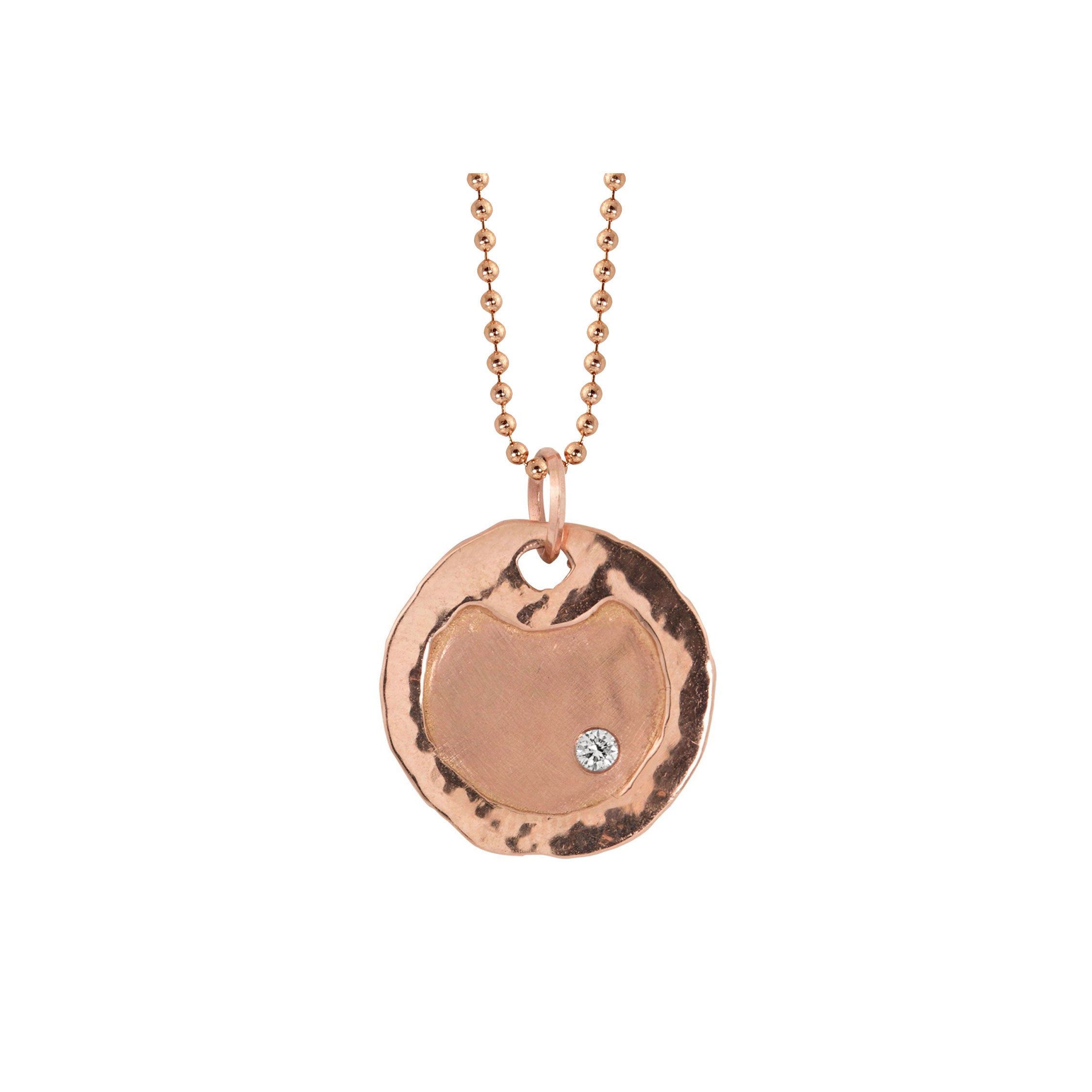 14k rose gold round dog tag with high polish hammered texture border set with single diamond on ball chain necklace with a round pendant on a white background