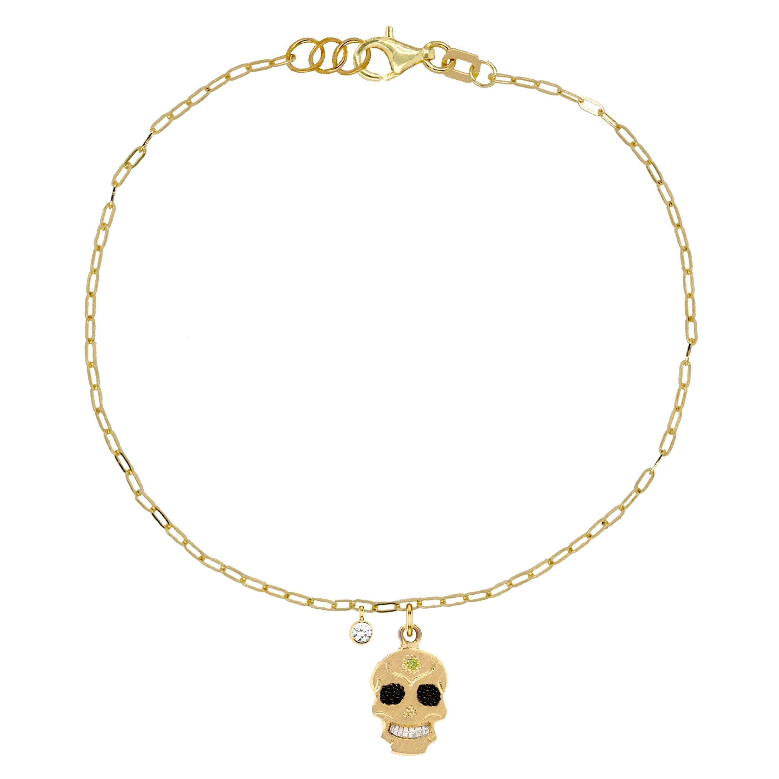 14k yellow gold teeny tiny ghostrider skull charm bracelet with colored gemstone and hand etching on paperclip link chain with white diamond bezi charm on white background