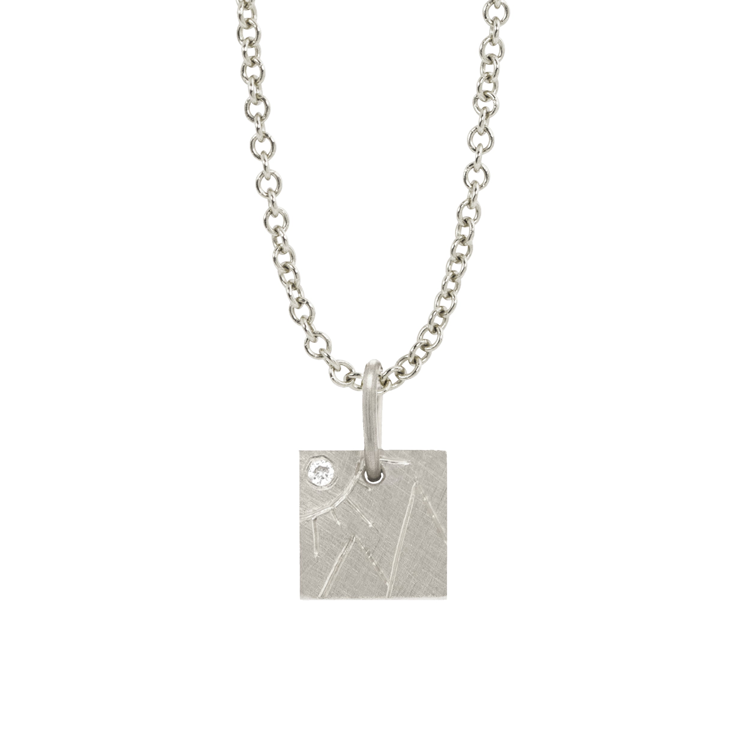 14k white gold square pendant with hand etched mountains and sun with white diamond on a white background