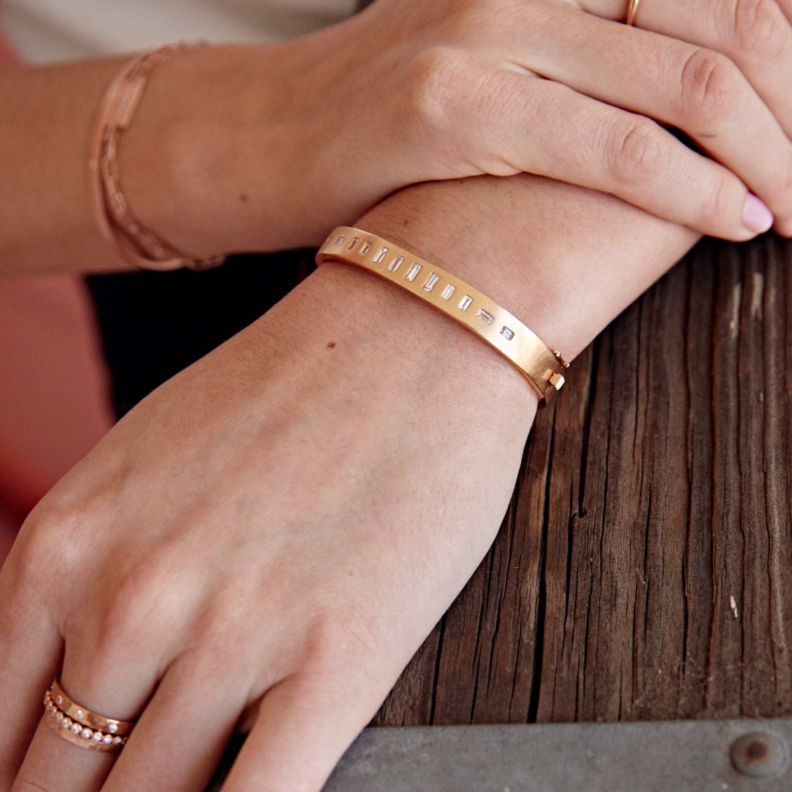 18k yellow gold hinged bangle bracelet with baguette cut white diamonds on model in lifestyle shot