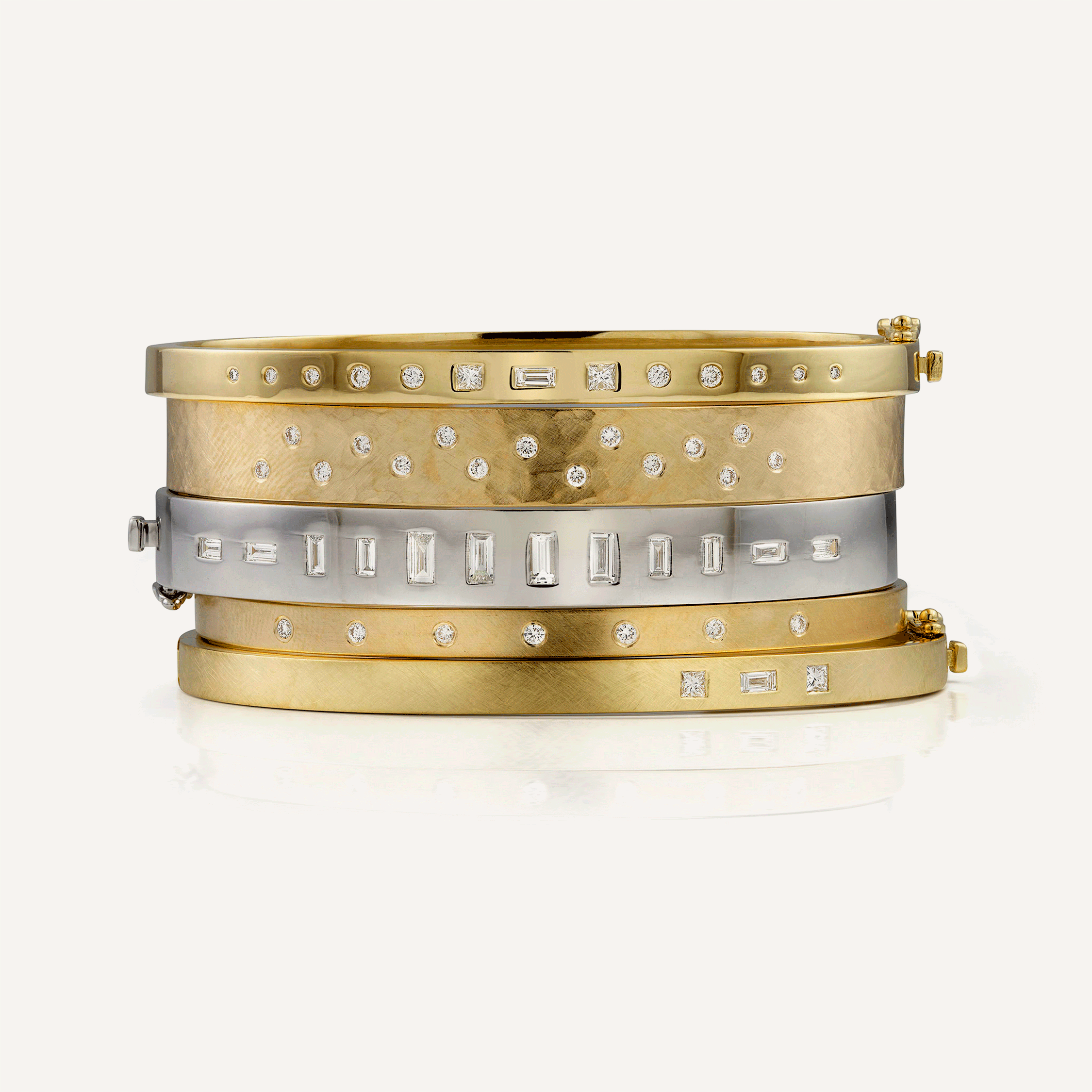 18k white gold hinged bangle bracelet with baguette cut white diamonds stacked with other hinged bangles and cuff bracelets by julez bryant on white background