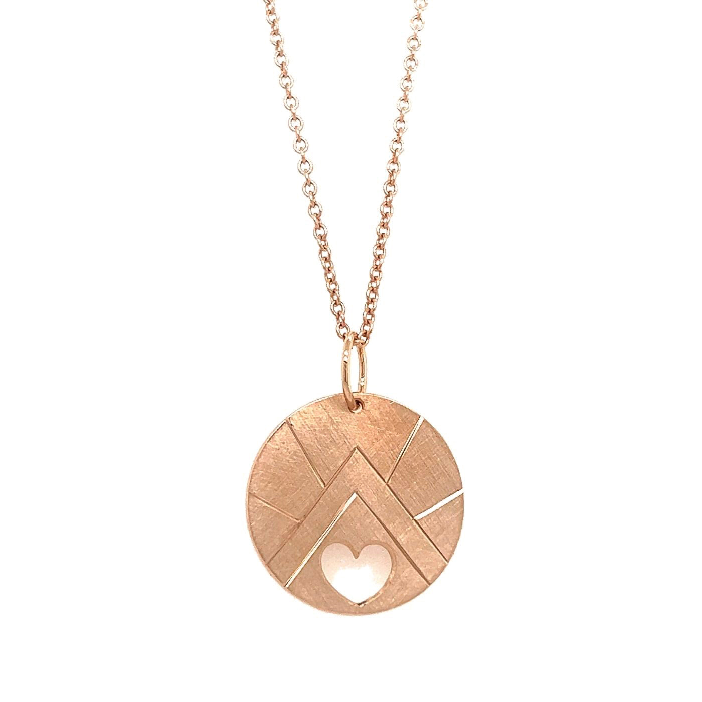 14k rose gold round pendant with geometric mountain etching and heart cut out on a white background