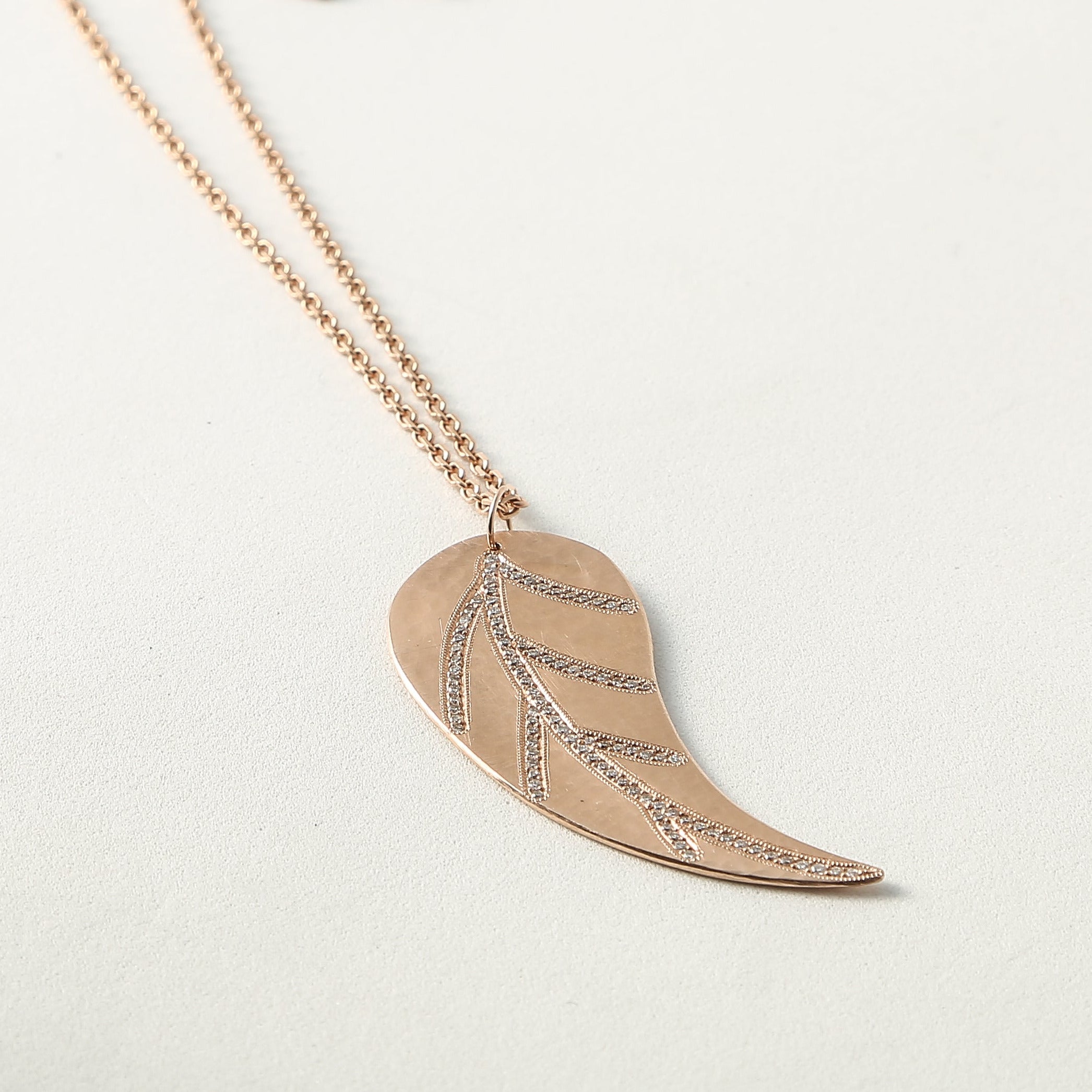 Rose gold necklace with a leaf-shaped pave diamond pendant with round link chain 2.2mm on a light background