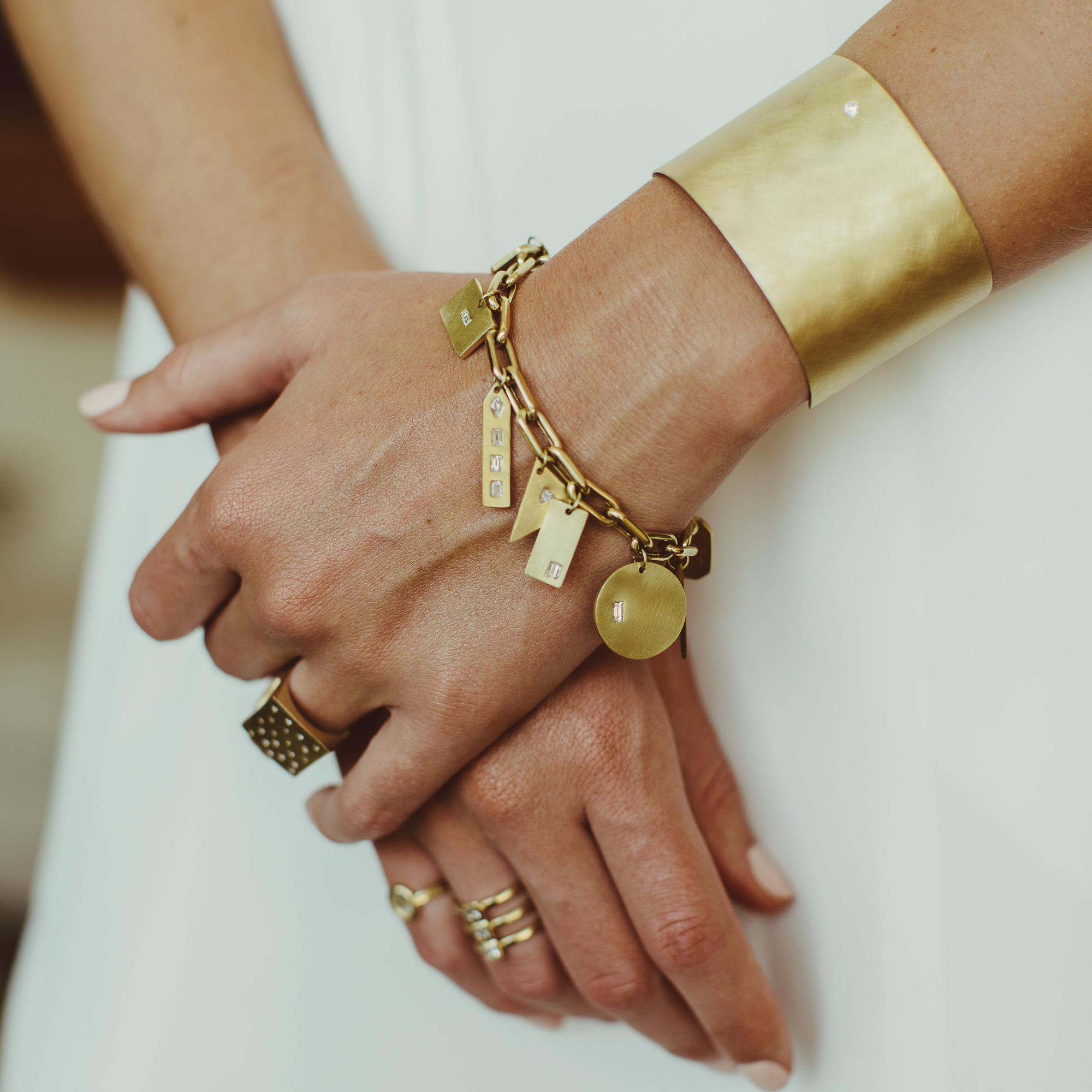 14k gold wide open cuff bracelet with white diamond accent on model in lifestyle shot