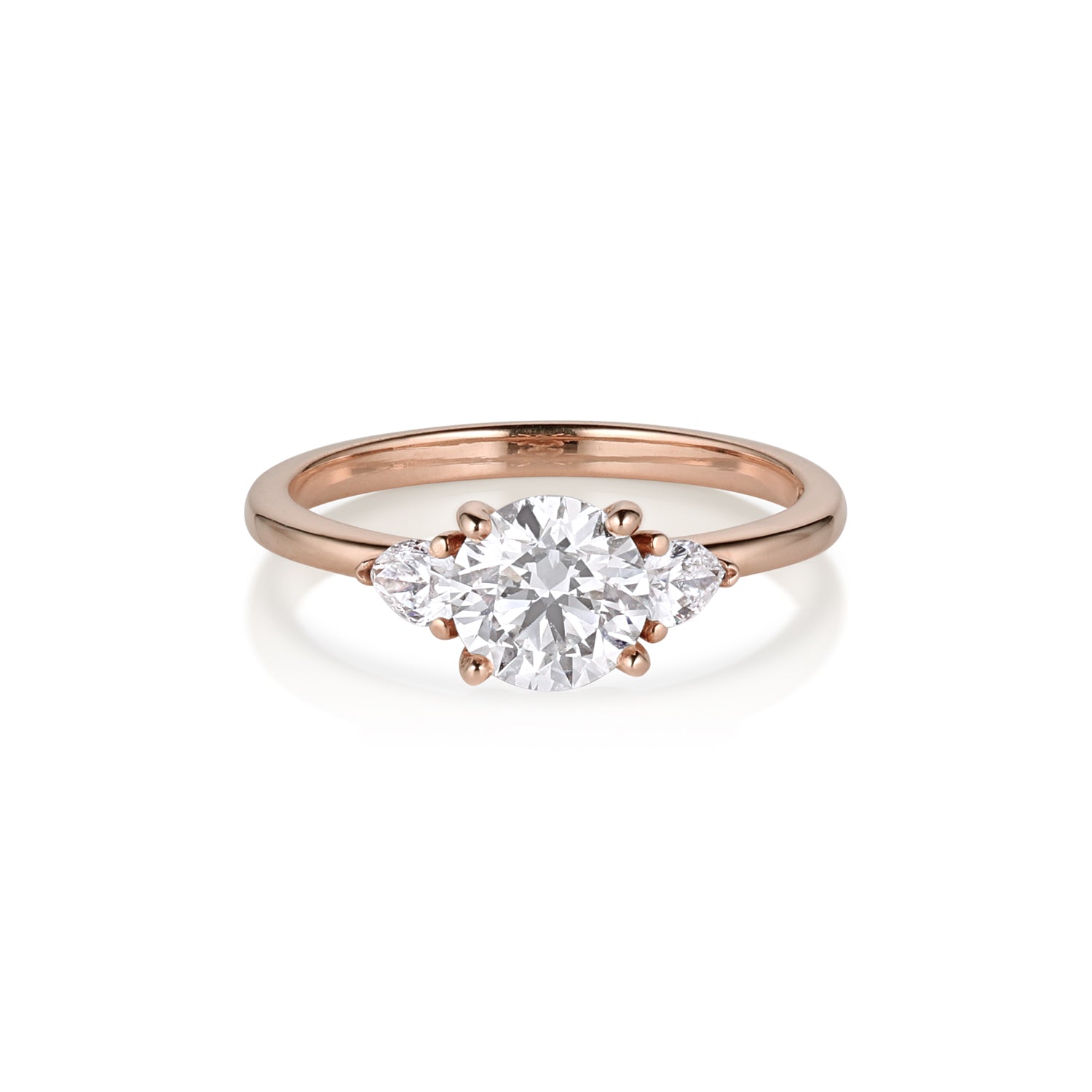 Rose gold 3 stone engagement ring with round and trillion shaped stones. On white background.