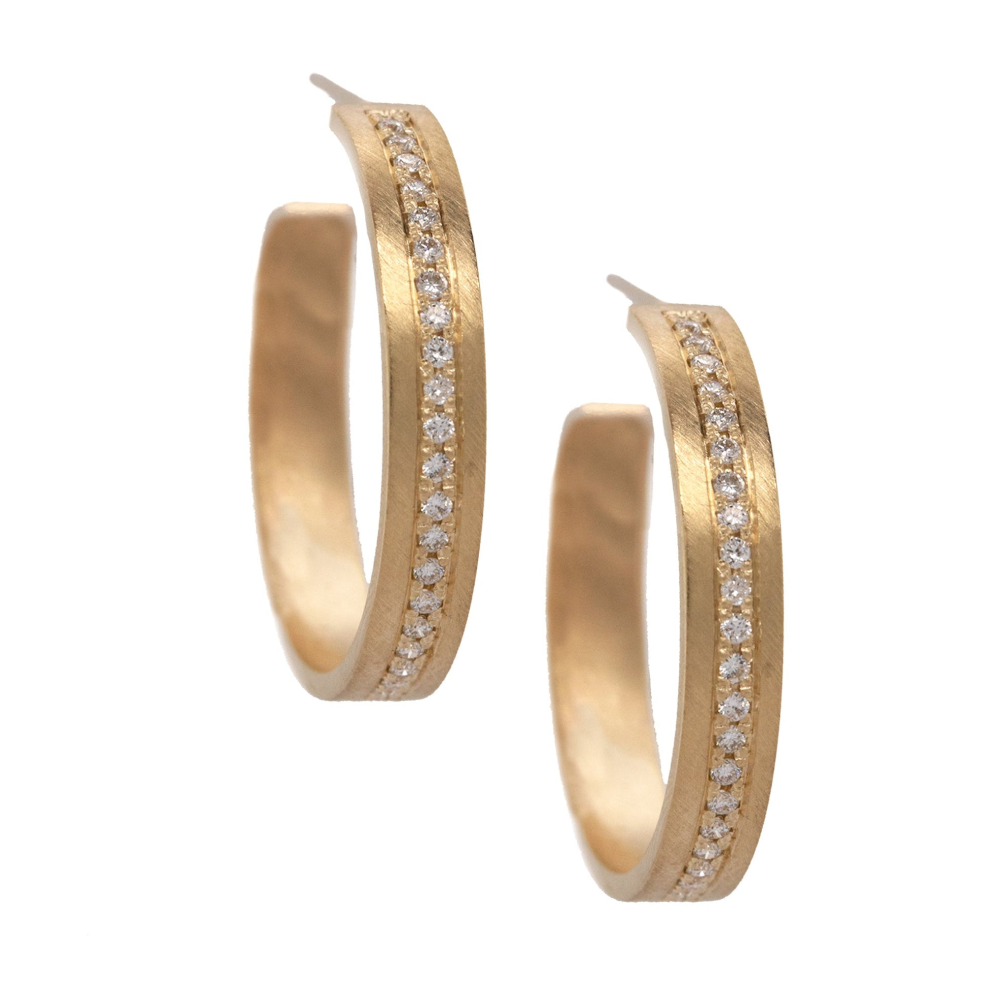 A pair of 14k yellow gold diamond hoop earrings with a satin finish and a continuous strip of paved set white diamonds shown on white background