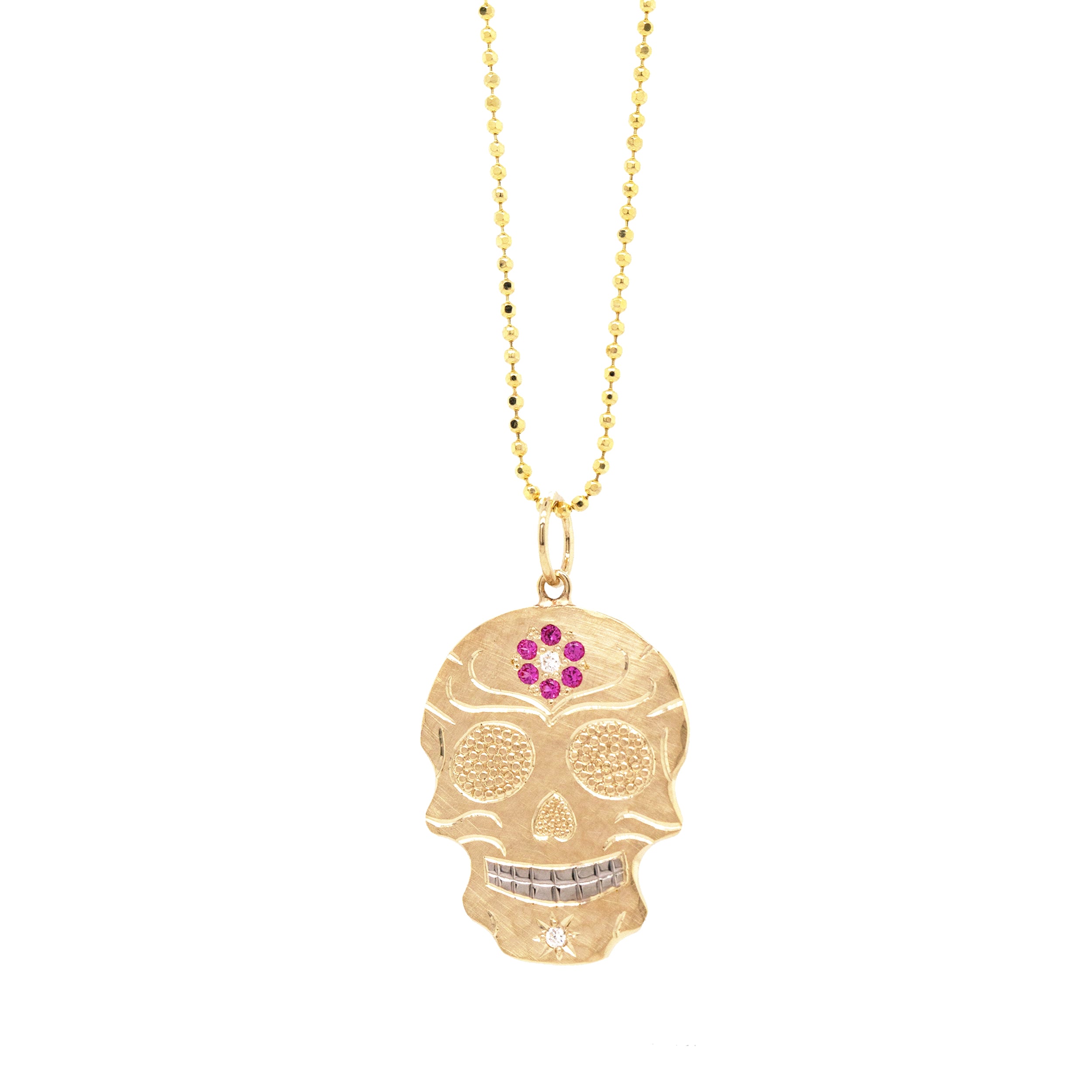 14k gold skull shaped pendant necklace with pink gemstone flower and hand engraving on a white background