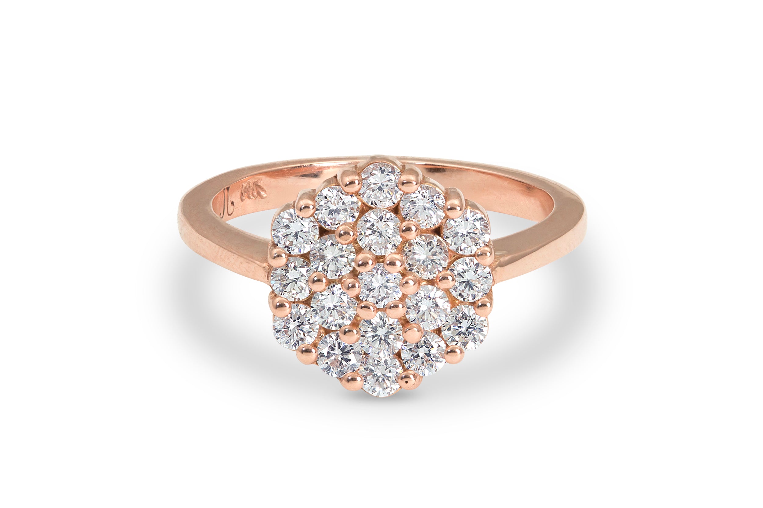 14k Rose gold ring with diamond cluster laying on side on a white background