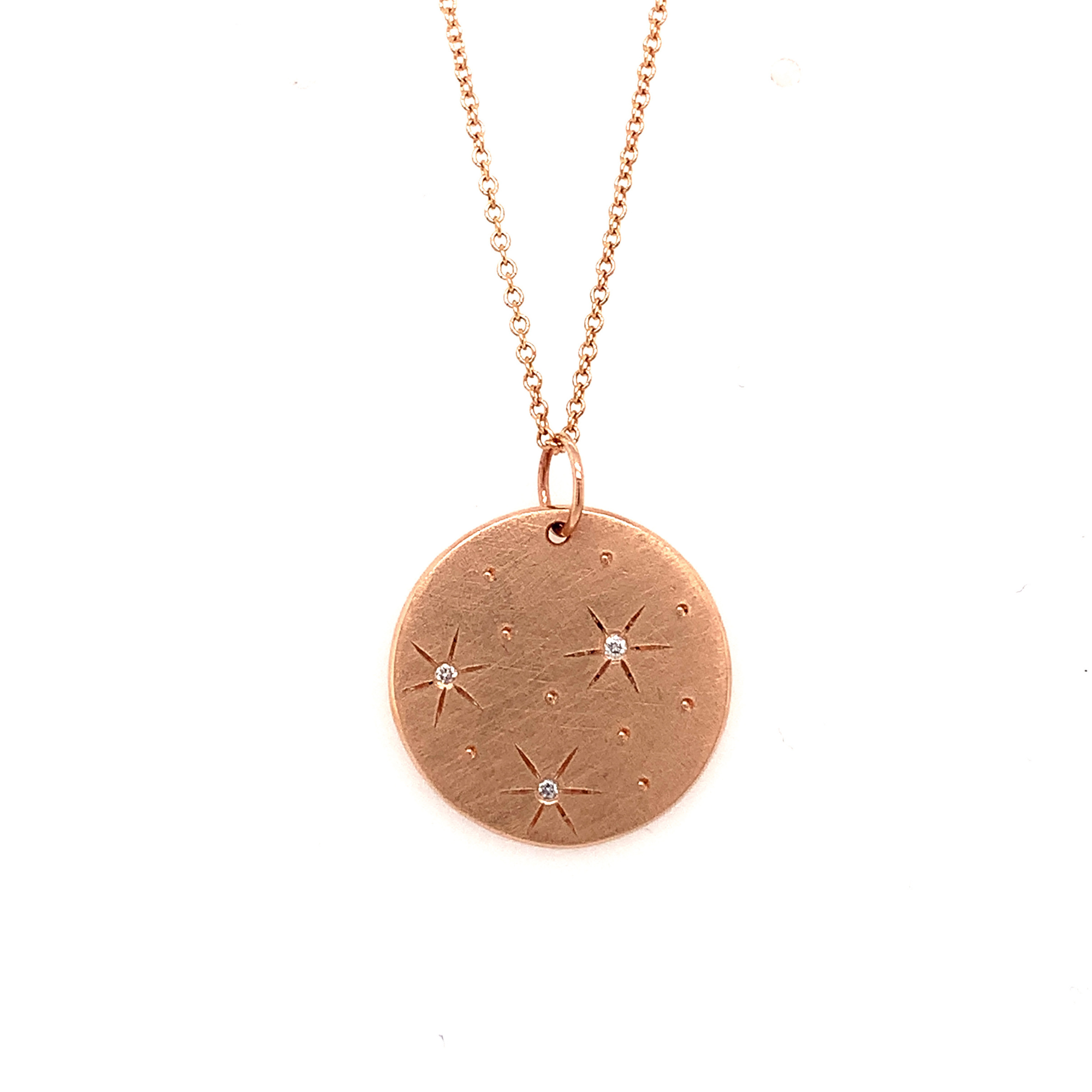 14k rose gold satin round pendant featuring white diamond starburst designs on a rolo chain on a white background