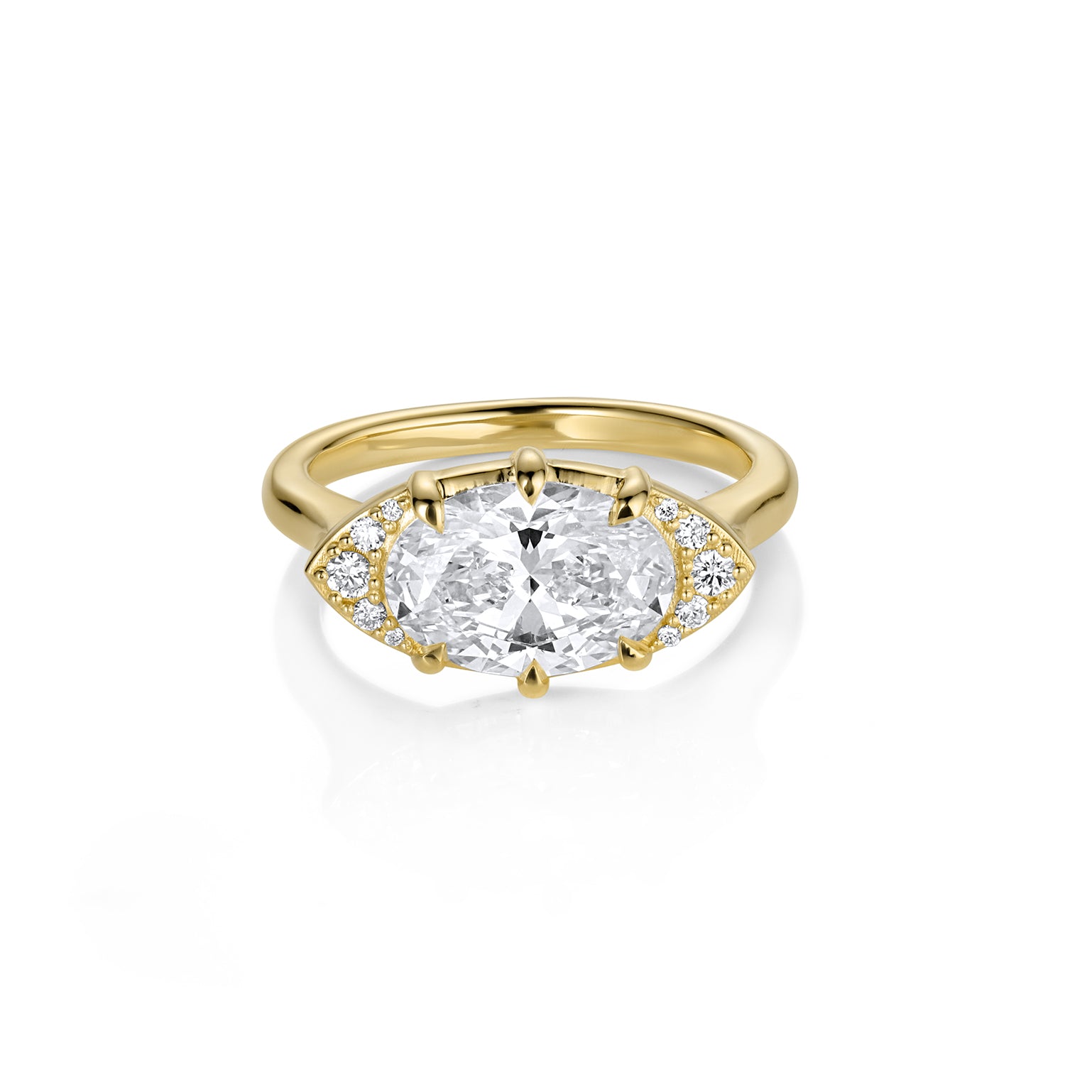 Gold ring with a large diamond and smaller diamonds on the band against a white background by Julez Bryant