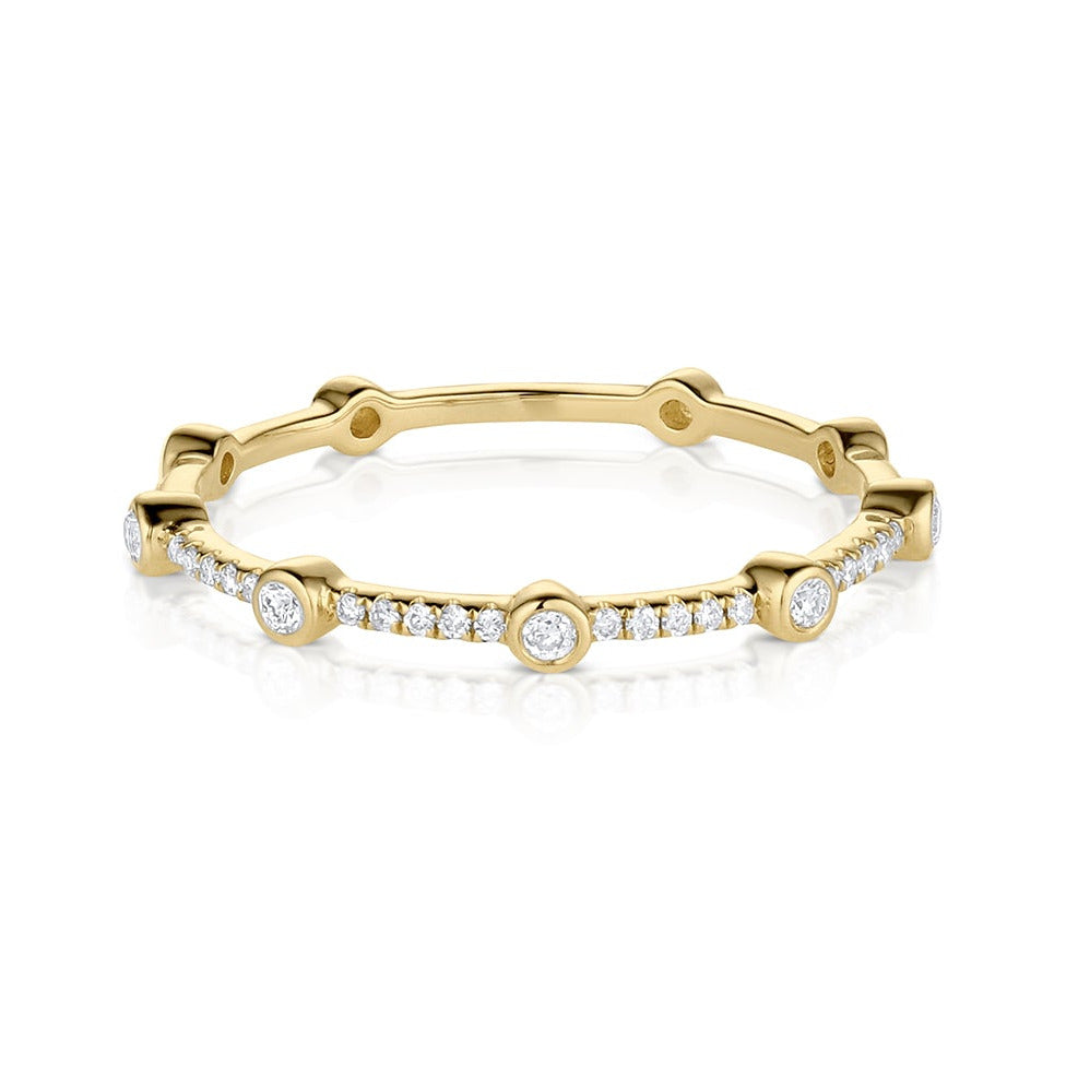 14k gold eternity ring with pave diamonds and bezel set diamonds on a white background