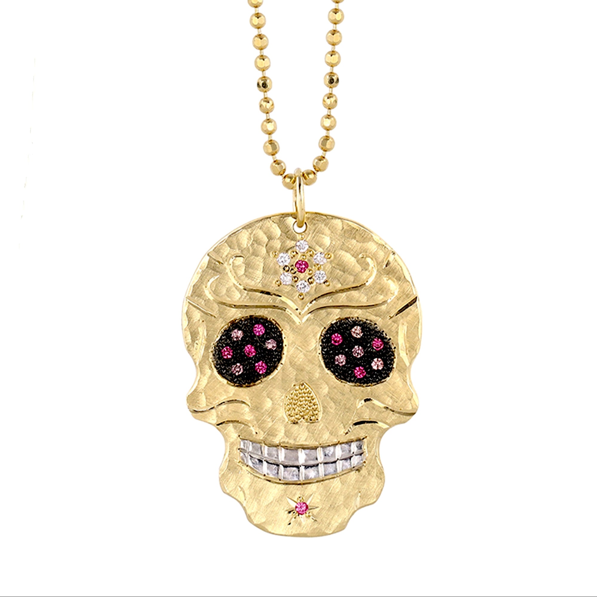 Large 14k gold hand cut skull pendant necklace with pink sapphire gemstones diamond flower on forehead on a white background