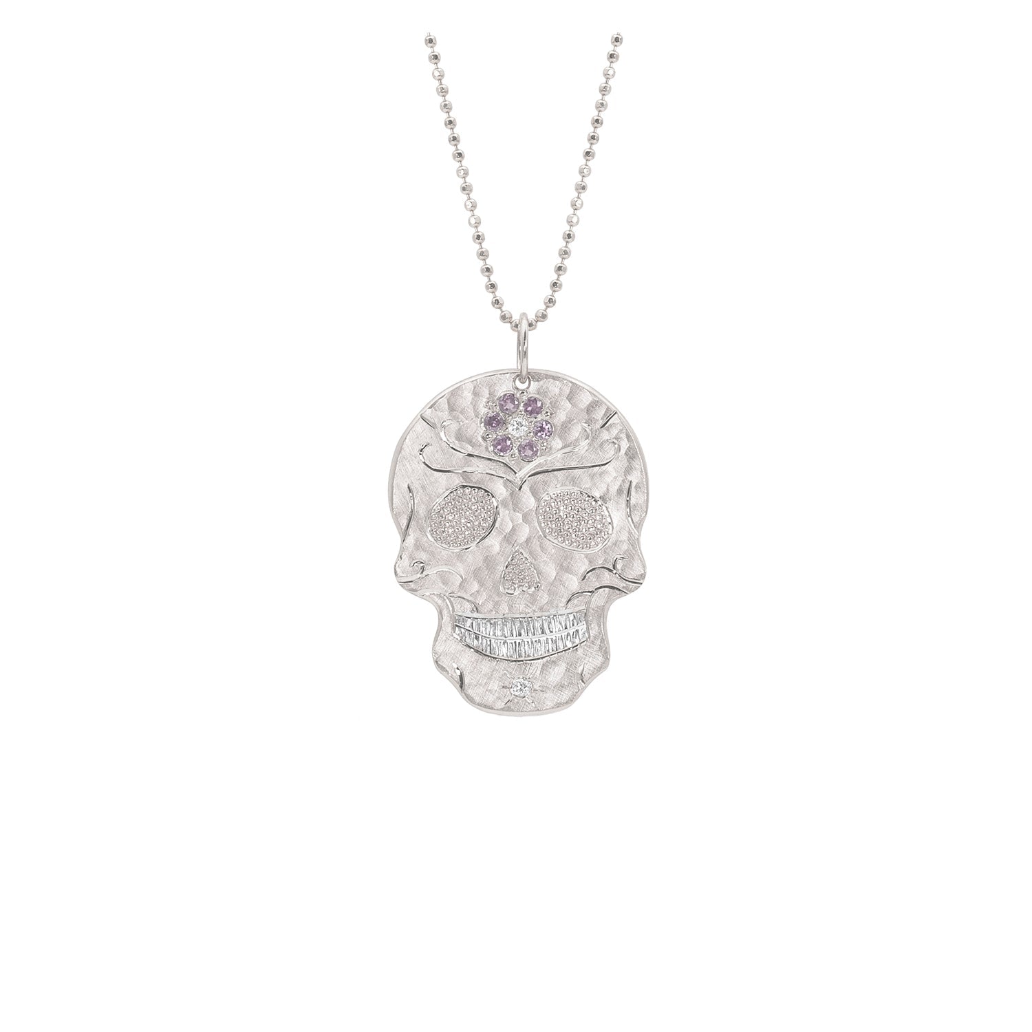 White gold sugar skull inspired cutout skull embedded with diamonds and pink sapphires, rhodium brightened teeth shown on faceted ball chain shown on white background
