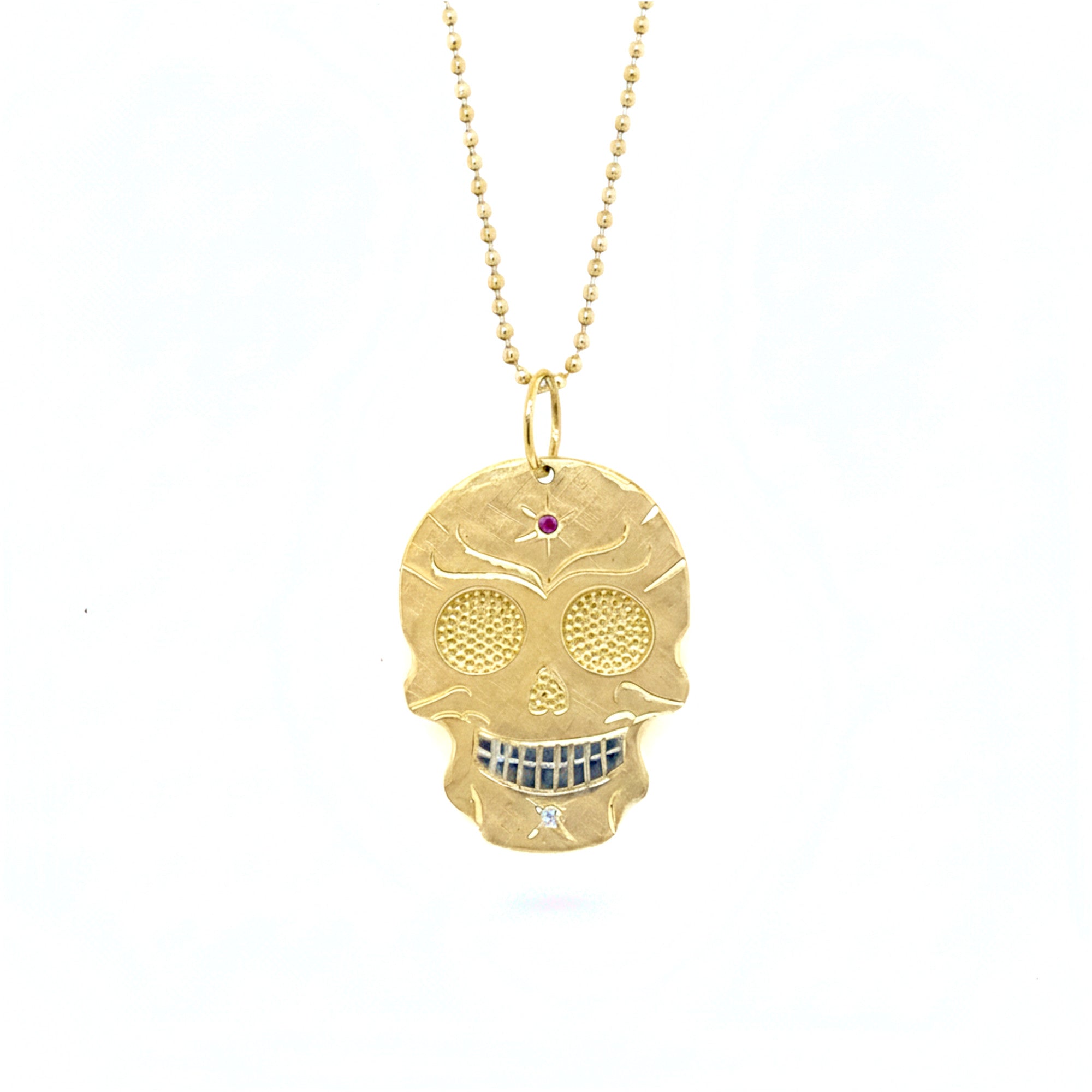 14k yellow gold skull pendant necklace with gemstones and bright eyes shown on a white background