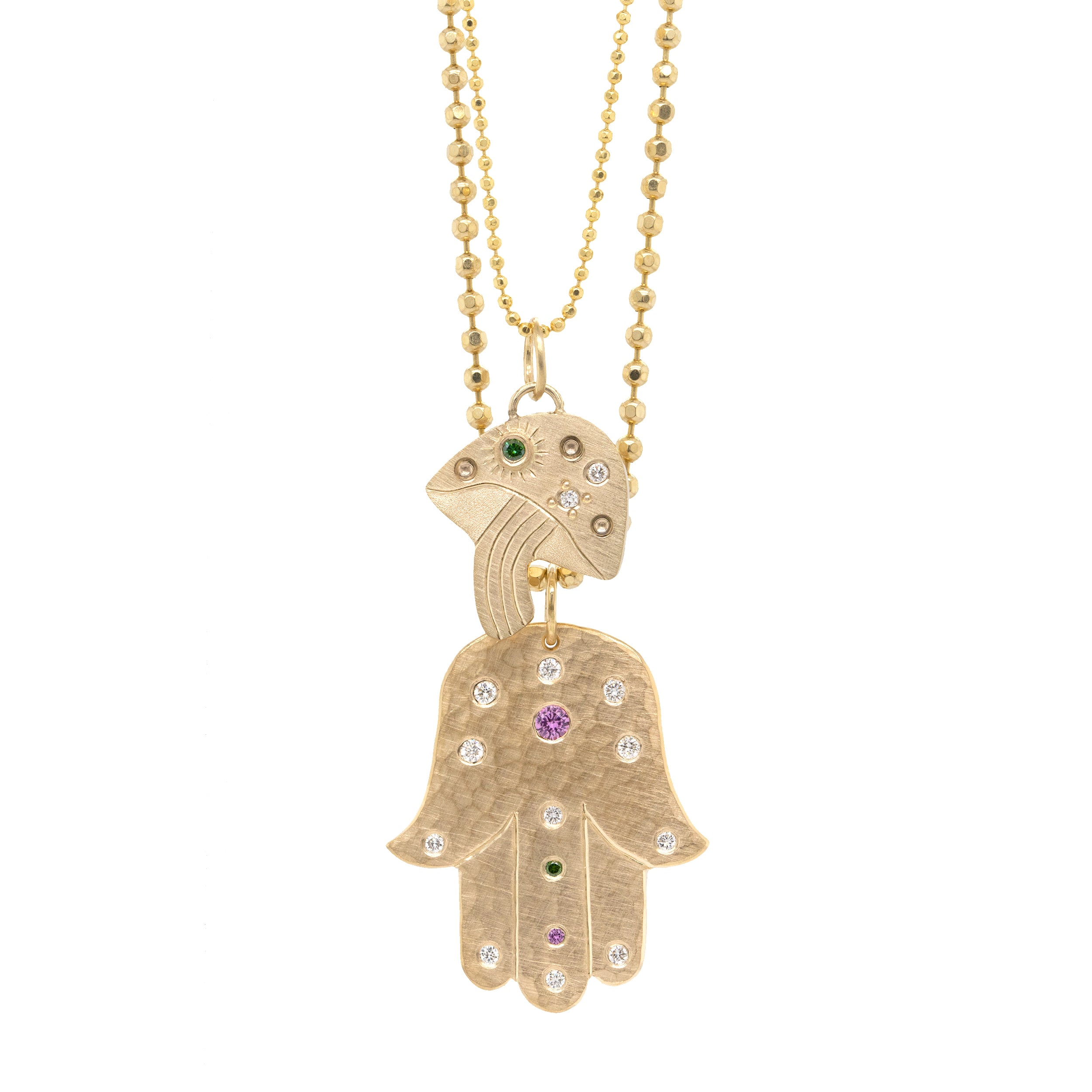 14k yellow gold Hamsa hand pendant with embedded colored gemstones paired with luma mushroom pendant featuring colored gemstones and hand etching on a diamond cut ball chain on a white background
