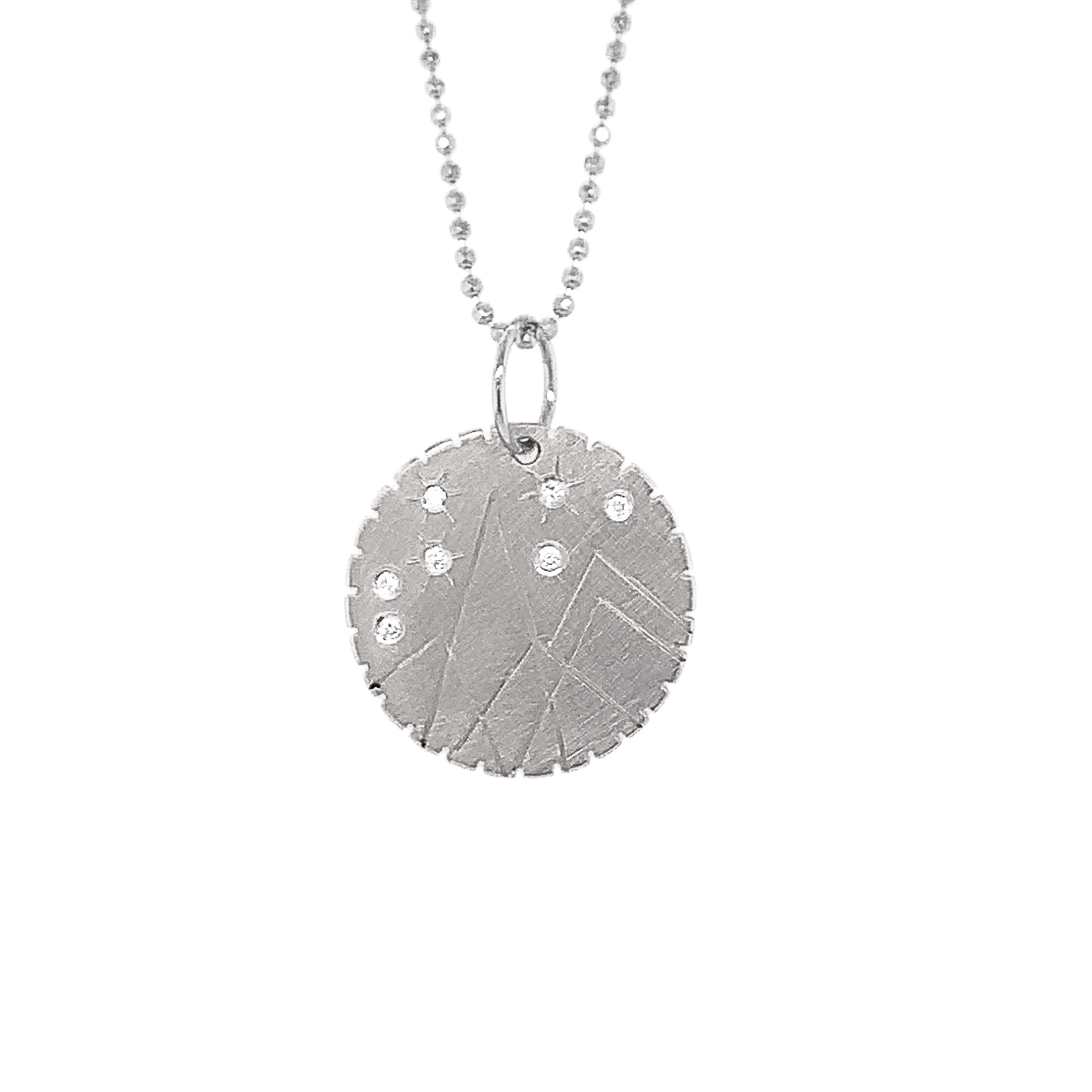 14k white gold round pendant with hand etched mountains and white diamond starbursts on a white background