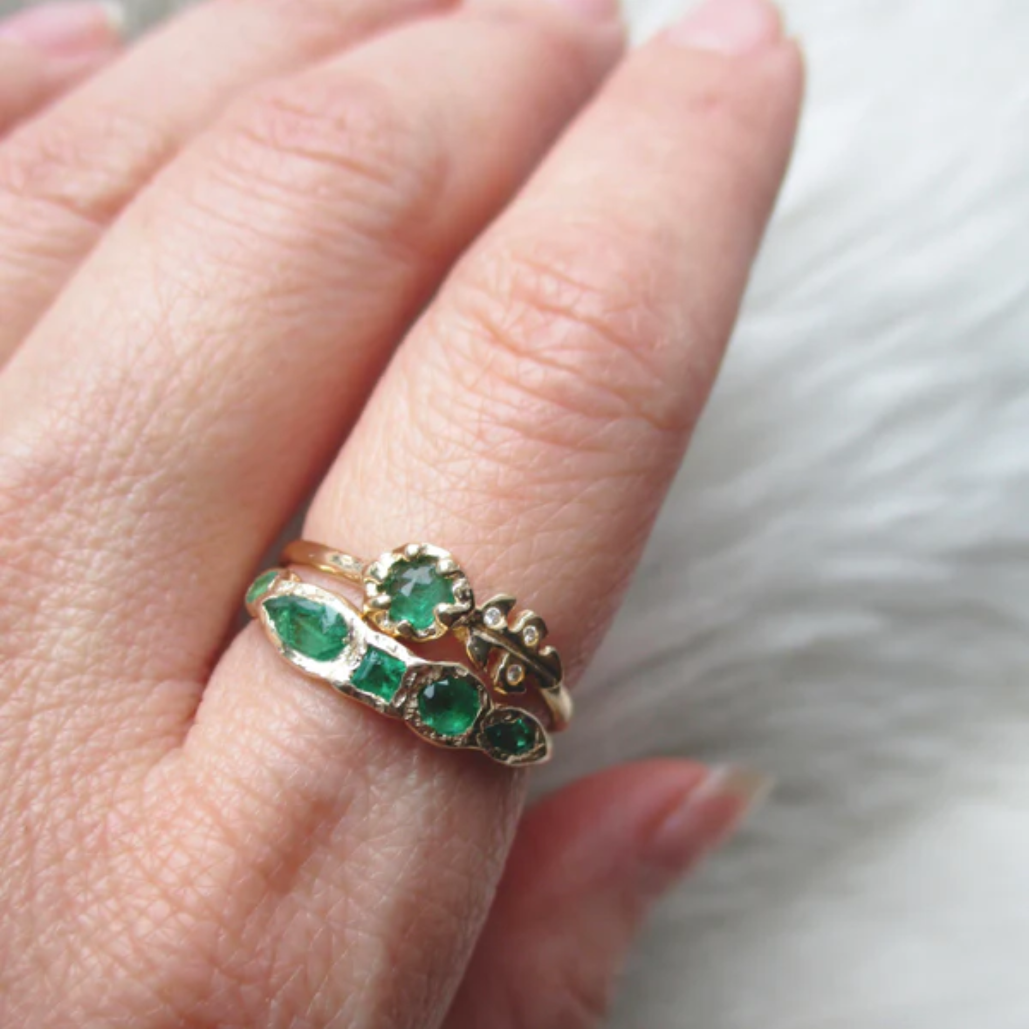 14k yellow gold ring with emeralds on model in lifestyle shot