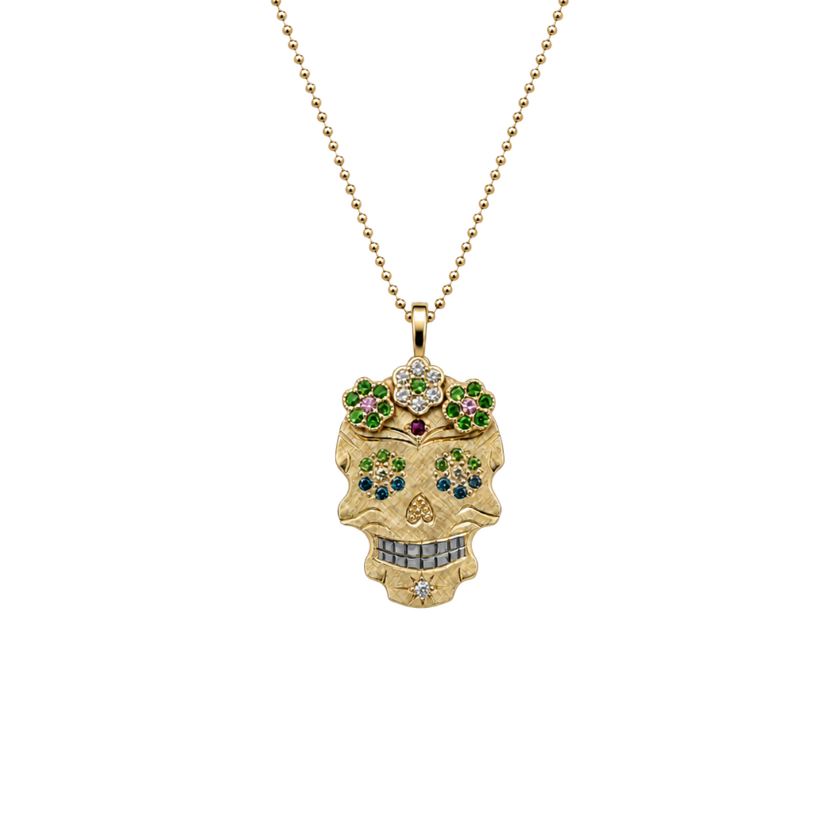 A gold sugar skull pendant necklace adorned with colorful gemstones, hanging from a gold ball chain against a plain white background.