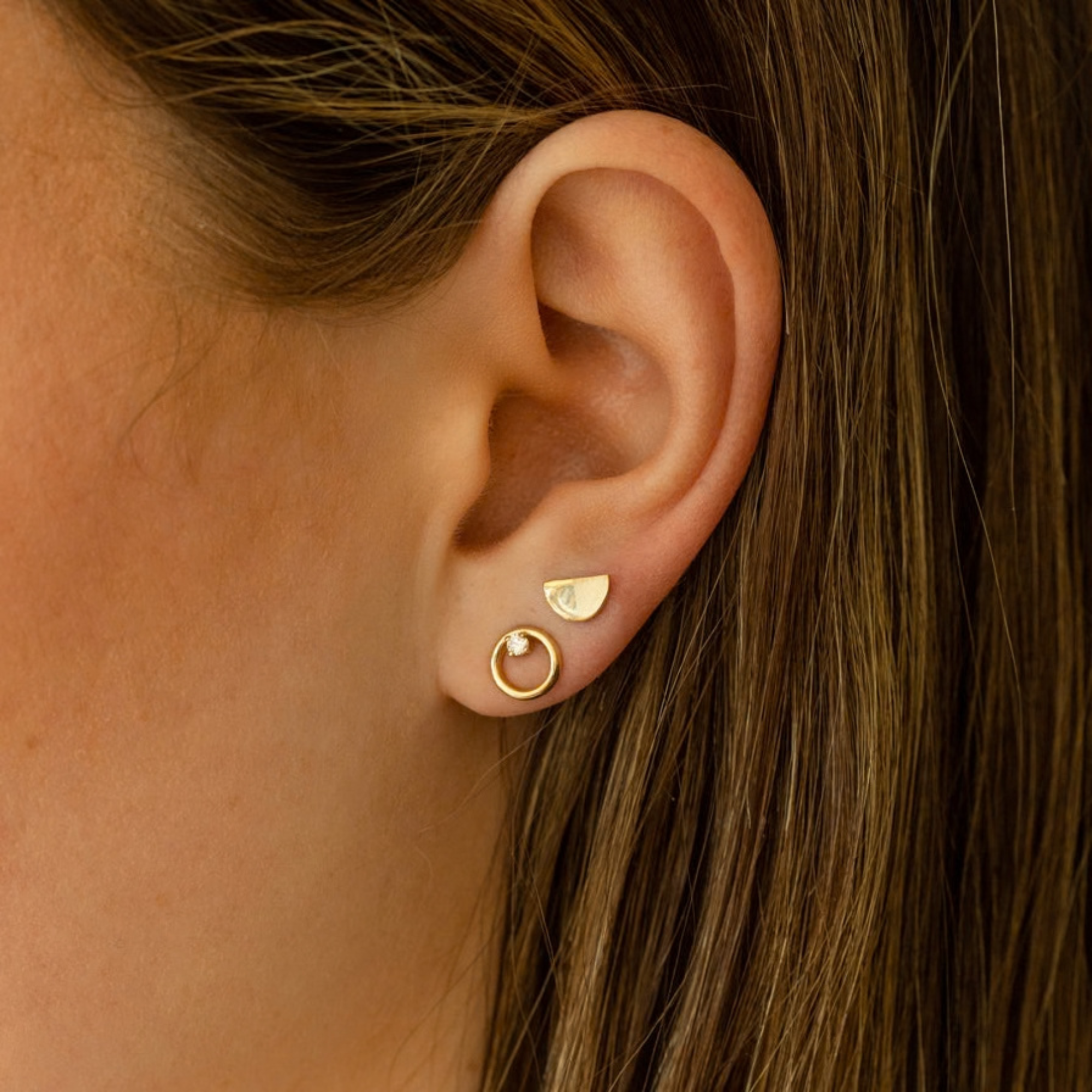 14k yellow gold open circle post earrings with white diamond accents on model in lifestyle shot
