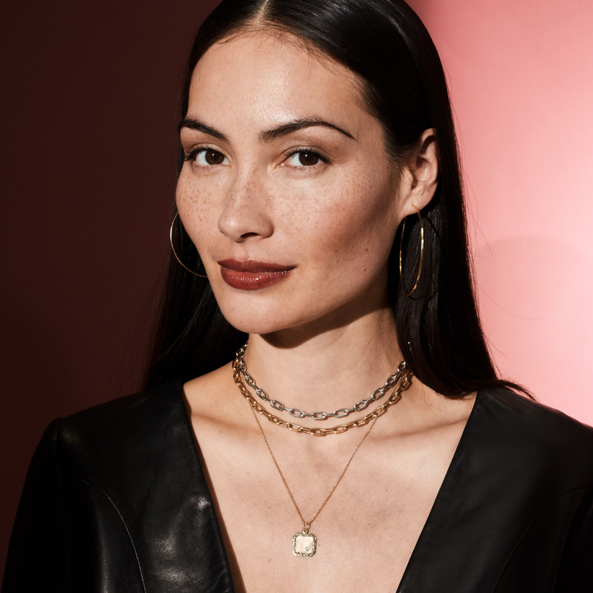 14k gold hammered wire hoop earrings styled with two mica chains in white and rose gold with square pendant with offset white diamond on diamond cut ball chain on model in lifestyle shot