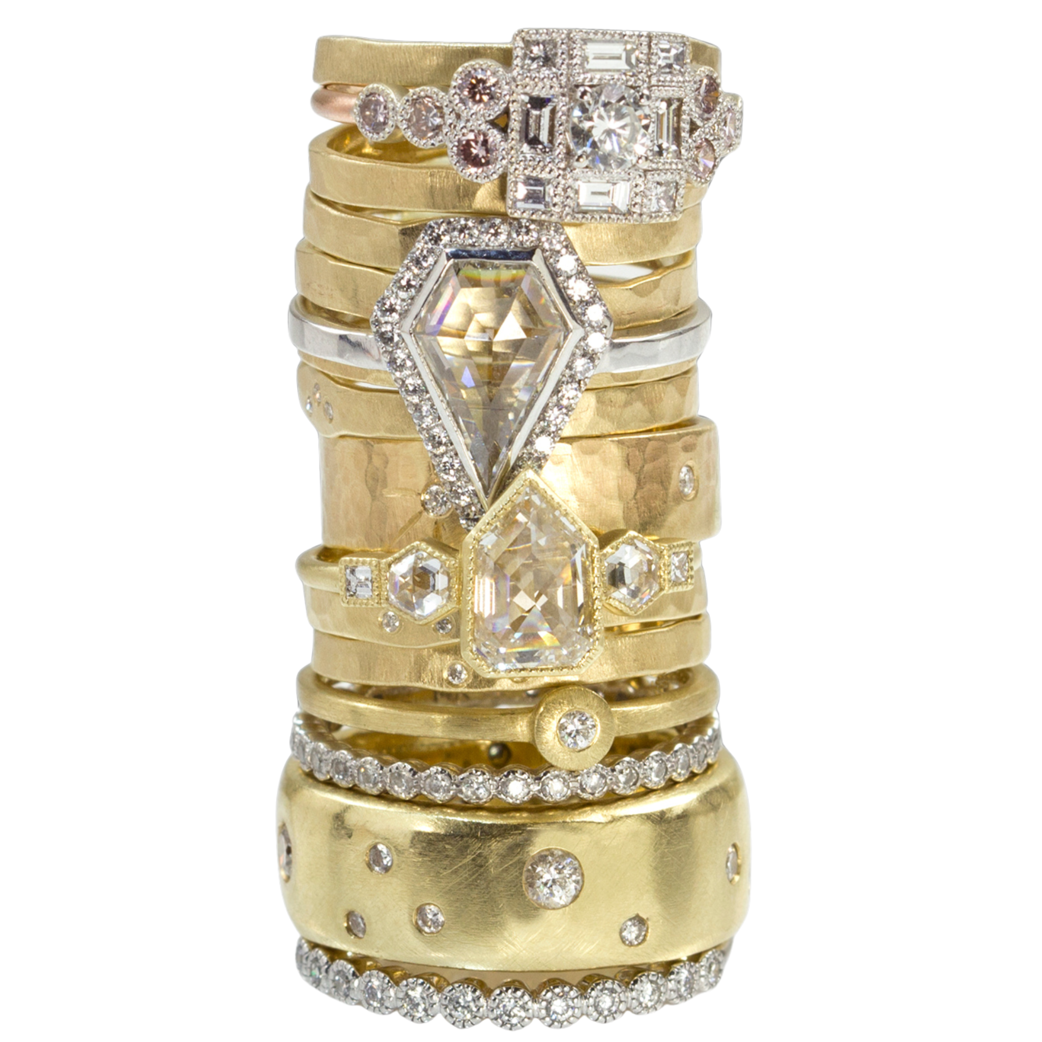High stack of 14k yellow gold and diamond engagement and wedding band rings of various designs unique diamond shapes shown on a white background
