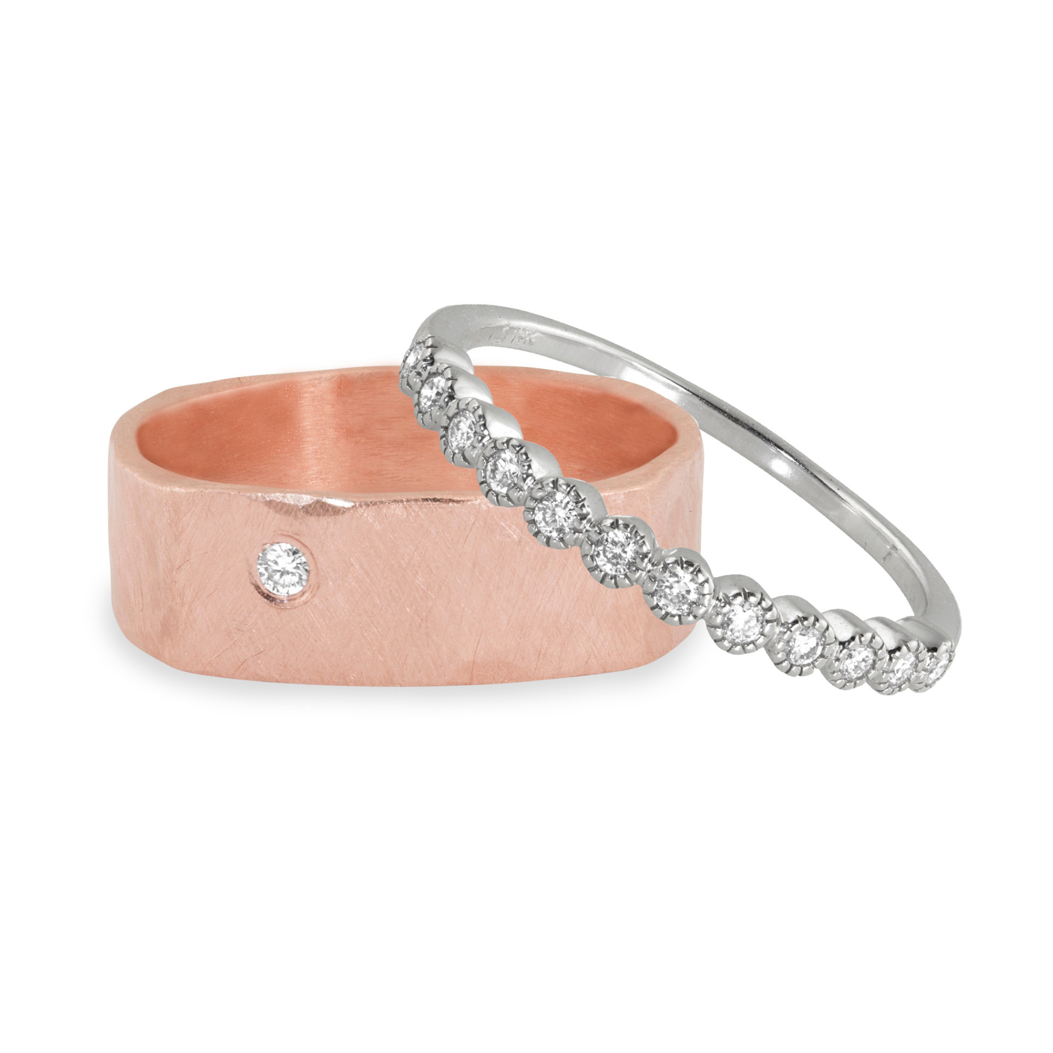 Two rings, one rose gold wide band with single white diamond hammered brushed finish and one white golf milgrain half eternity band with diamonds, on a white background.