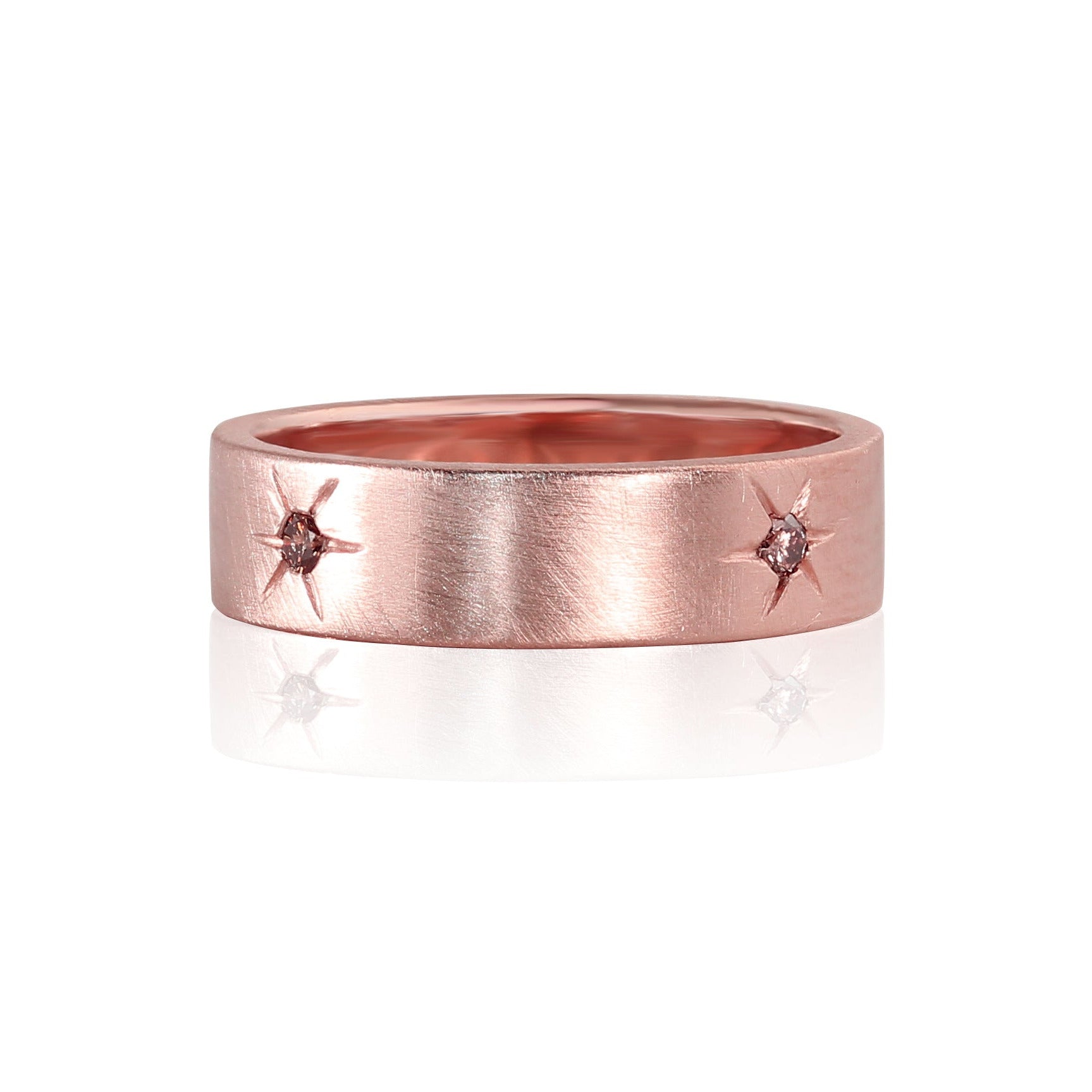 14k rose gold ring with embedded pink gemstones and engraved starburst details encircling band satin brushed finish shown laying flat on a white background