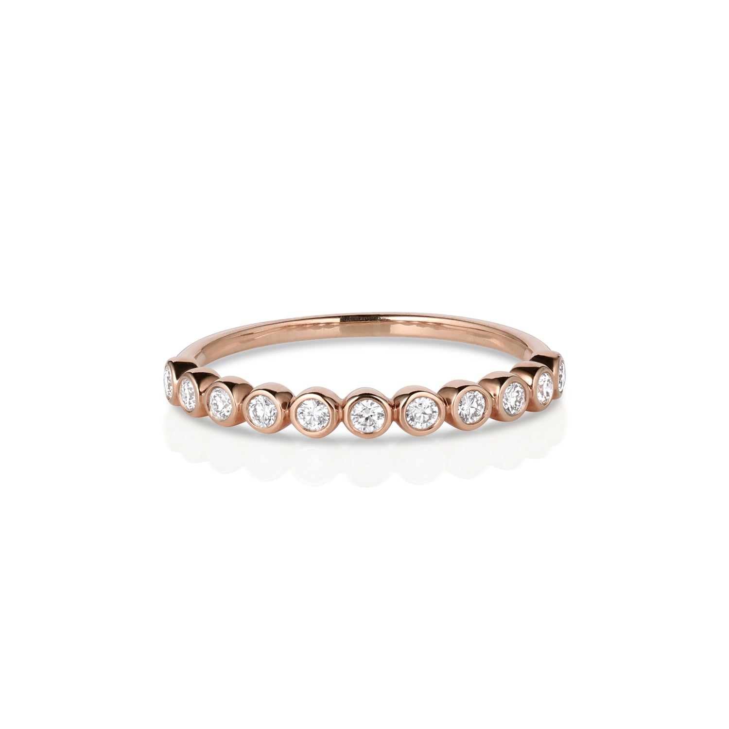 Rose gold ring with round bezel set diamonds, half eternity setting on a white background