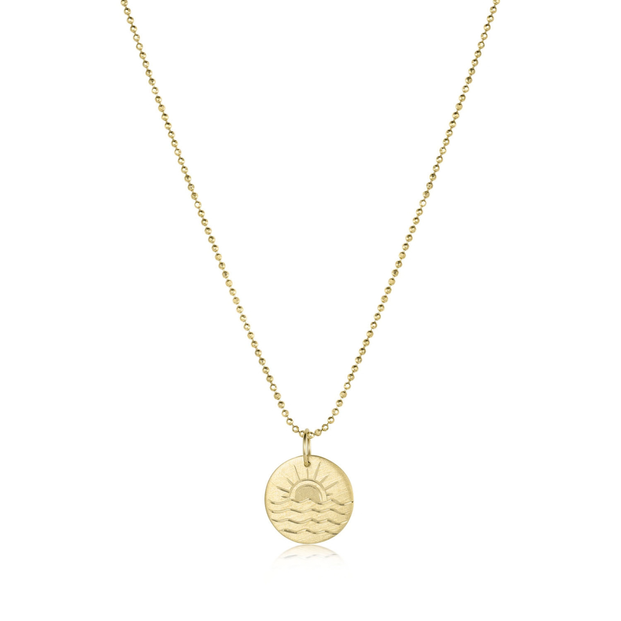 14k yellow gold round pendant with engraved sunset and waves on a white background