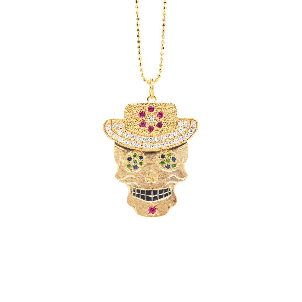 Gemstone encrusted sugar skull wearing cowboy hat yellow gold black rhodium darkened teeth. Extra large pendant in 14k solid yellow gold mixed diamond sapphires and Tzavorite. Fine detail engraving highlights features. Hat of flower clustered jewels in mixed colors. Eyes with green Tzavorite and blue sapphire pave set gemstone eyes. Large pink sapphire Flower pave set detail on hat. Shown on 2.0mm ball chain.