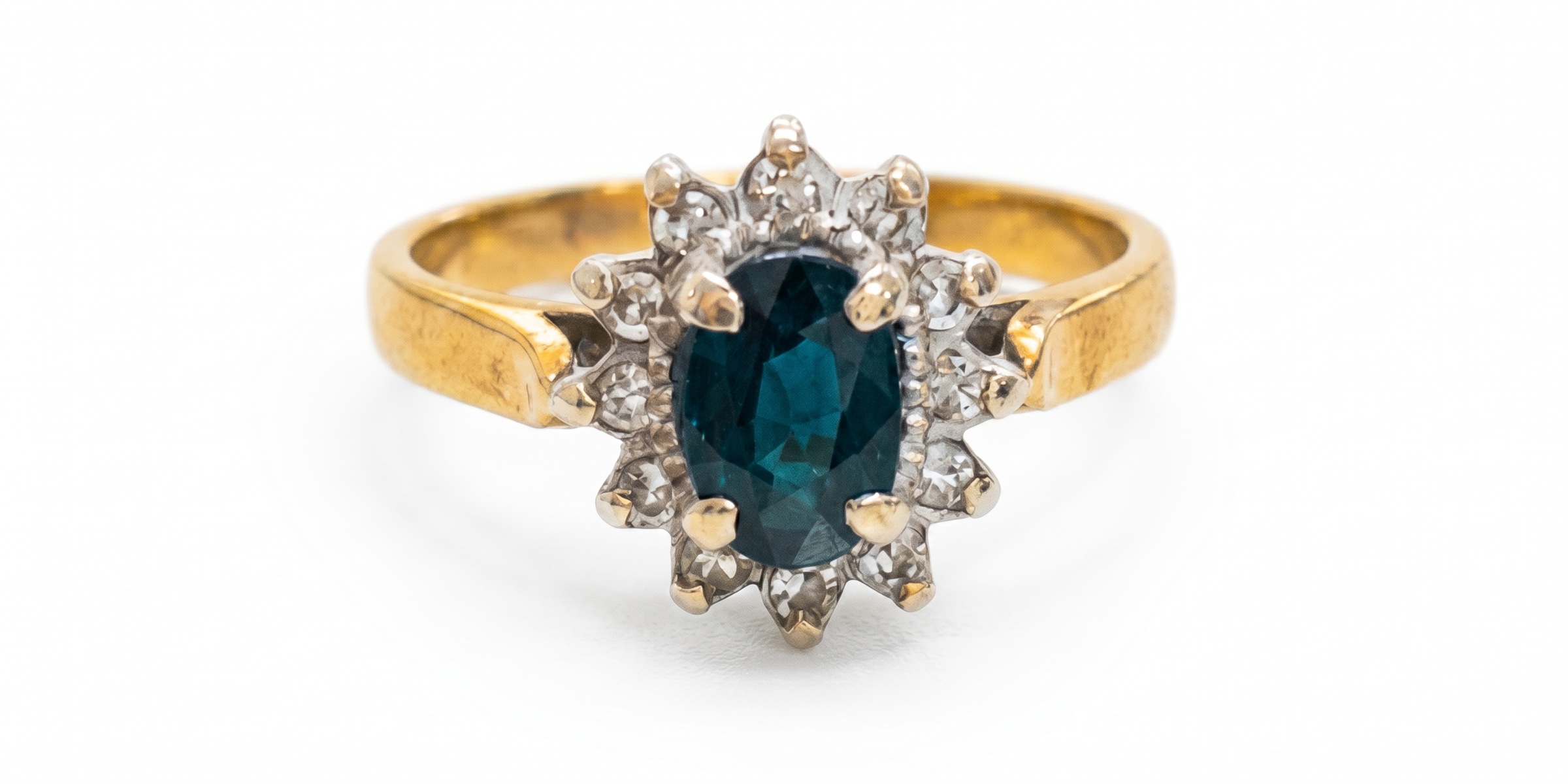 Vintage gold ring with a teal-blue faceted gemstone and diamond accents cluster ring before picture shown close up on a white background