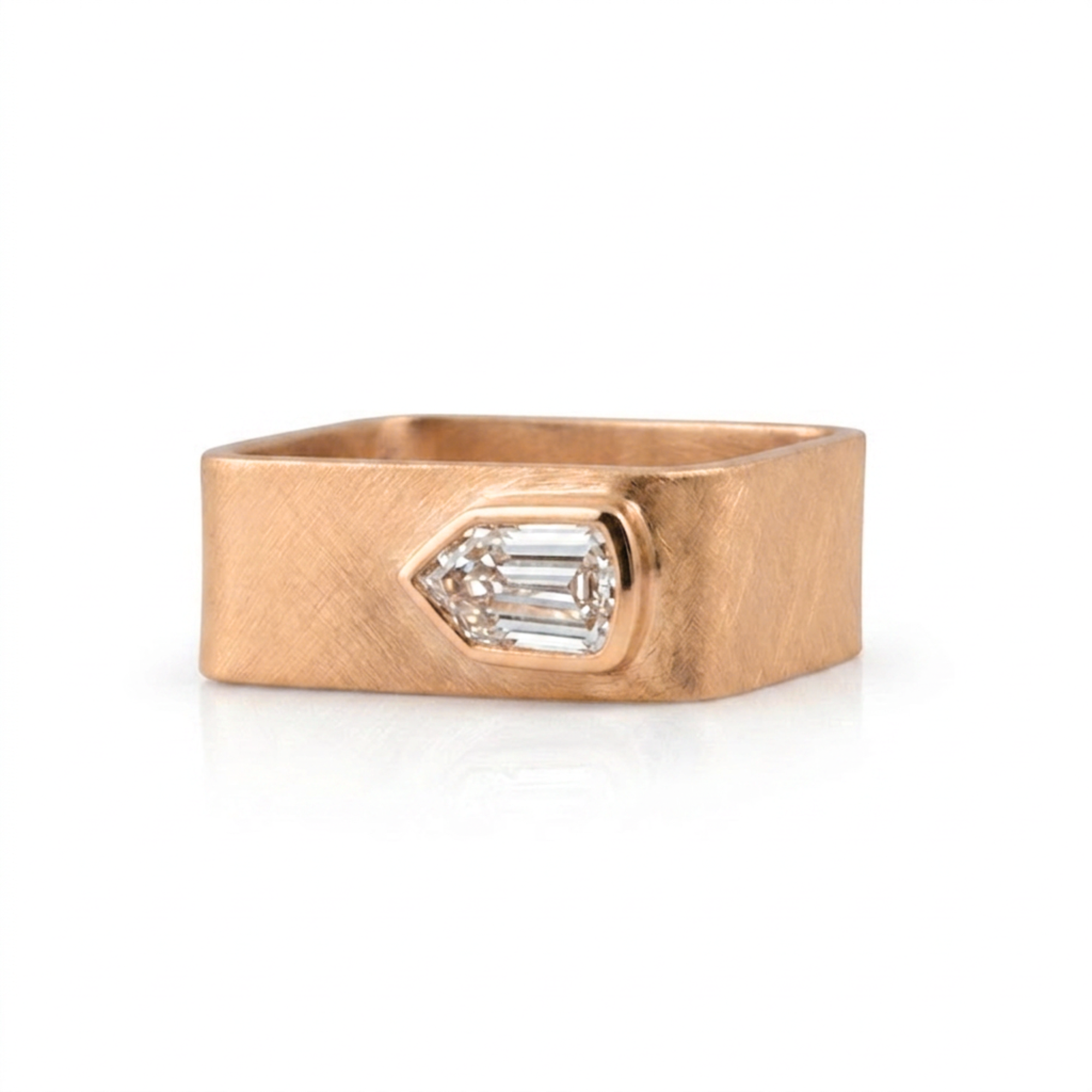 Wide band geometric shield cut diamond bezel solitaire ring in 14k rose gold, front view on a white background
