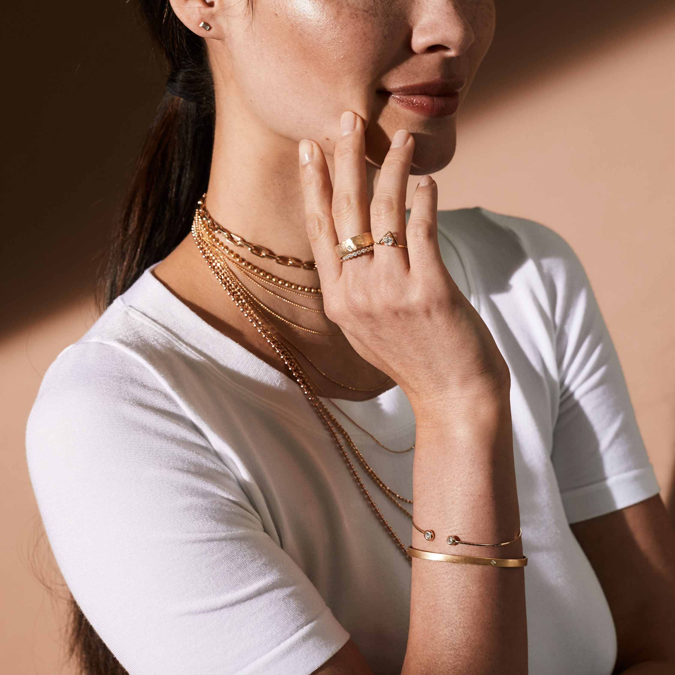 14k yellow gold BOLI cuff bracelet with single diamond on model with PELI bracelet