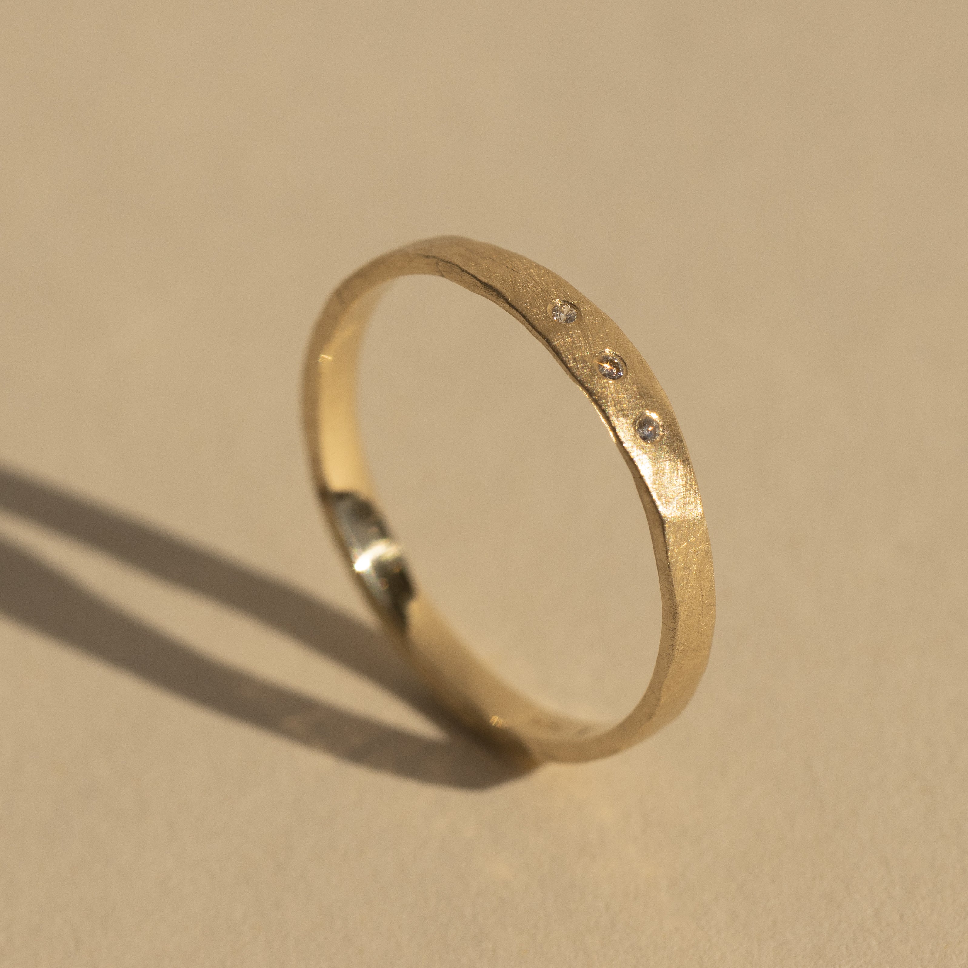 14k yellow gold PRIM stacker ring with 3 diamonds in studio image
