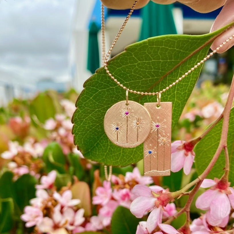 14k gold GIKI and GIKA pendants in garden
