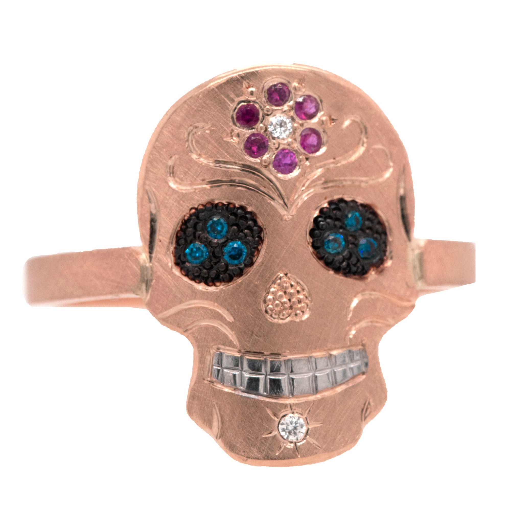 Rose gold skull ring with gemstone eyes on a white background