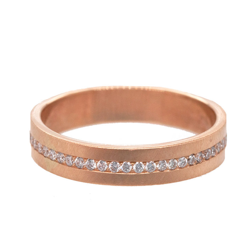 A 14k rose gold ring band with a satin finish and a continuous strip of pave set white diamonds.