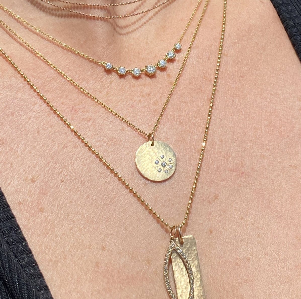 14k gold SKYE starburst charm with white diamonds on model