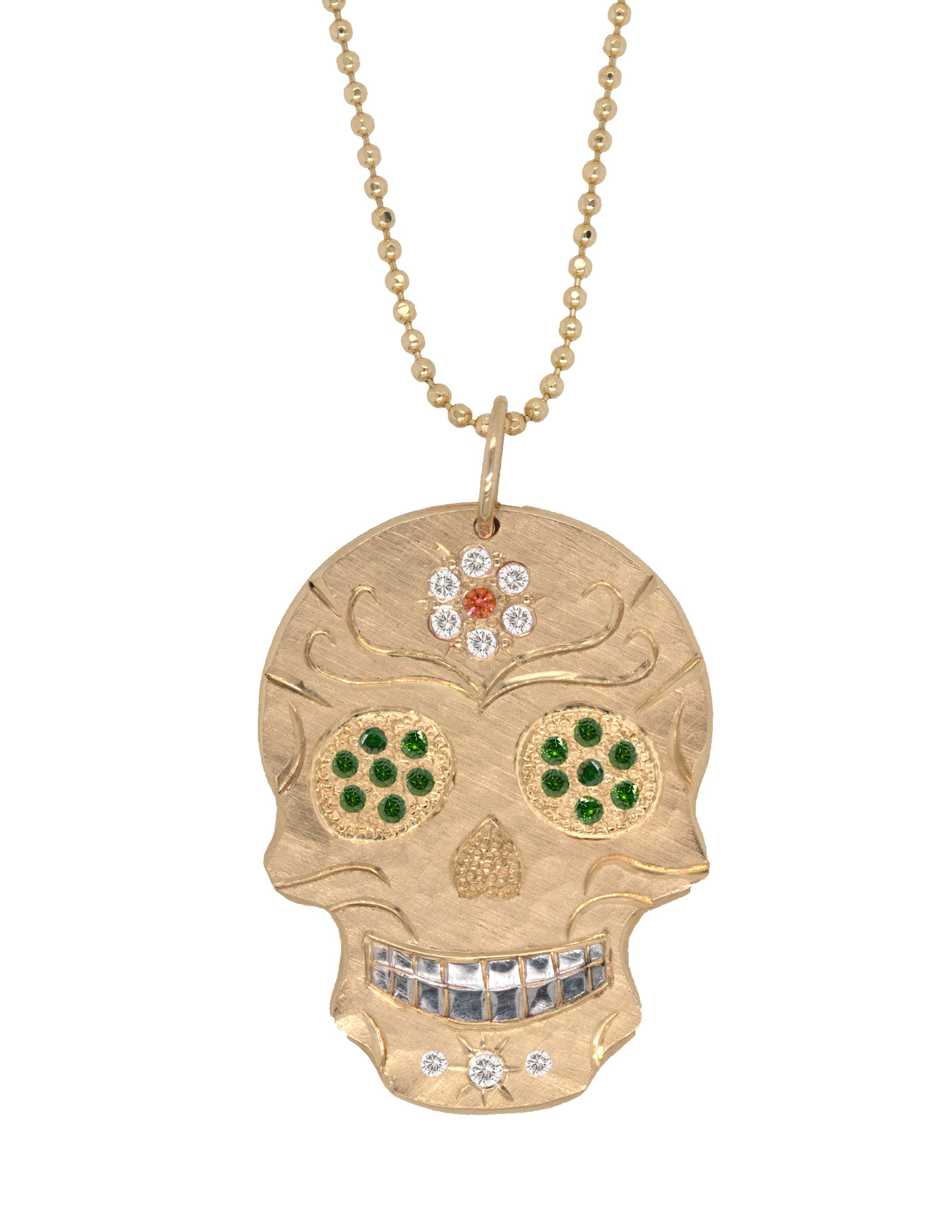 Gold skull pendant necklace with gemstones on a white background by Julez Bryant